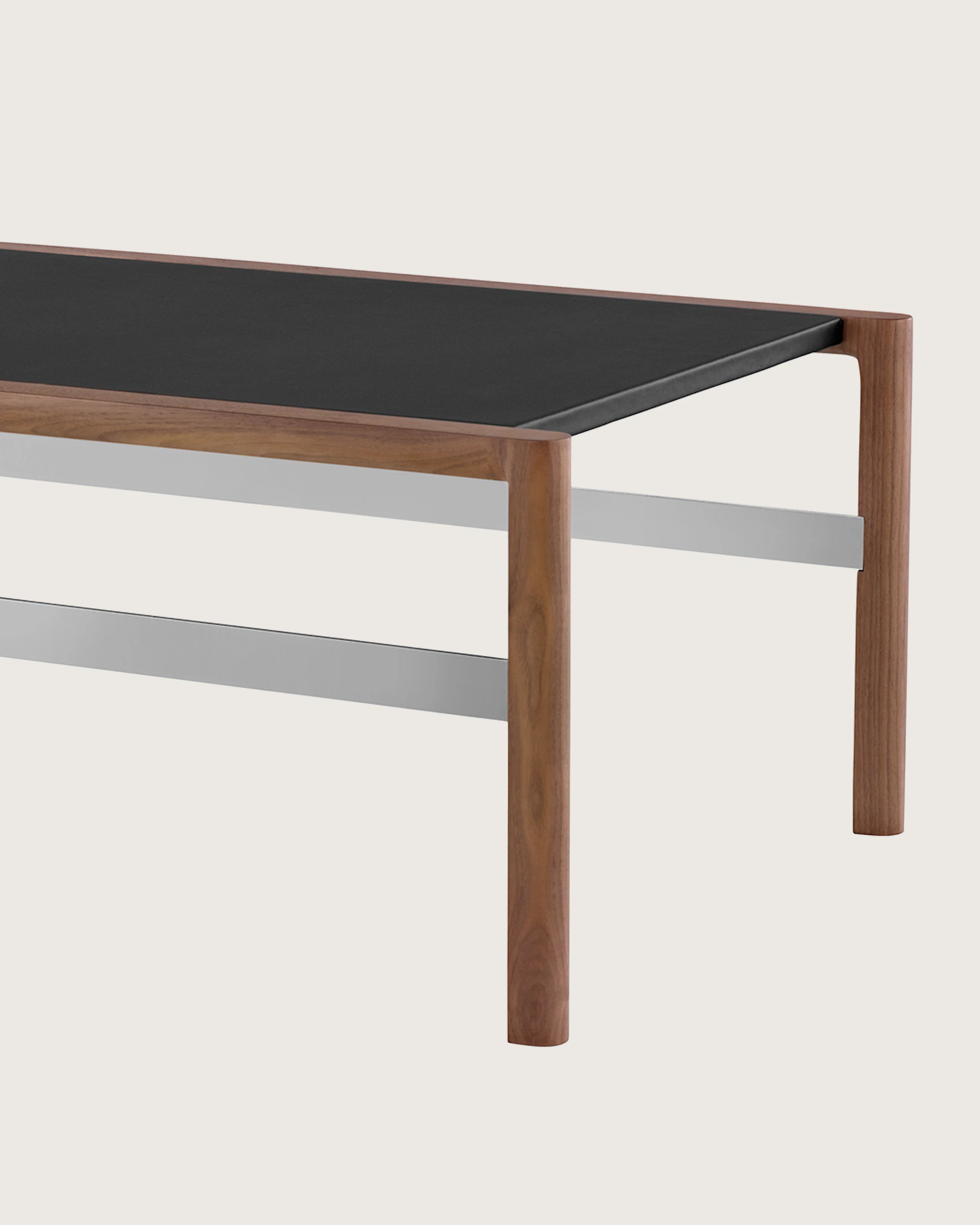 A rectangular Brabo Table with a leather-wrapped top and metal frame supports, viewed at an angle.