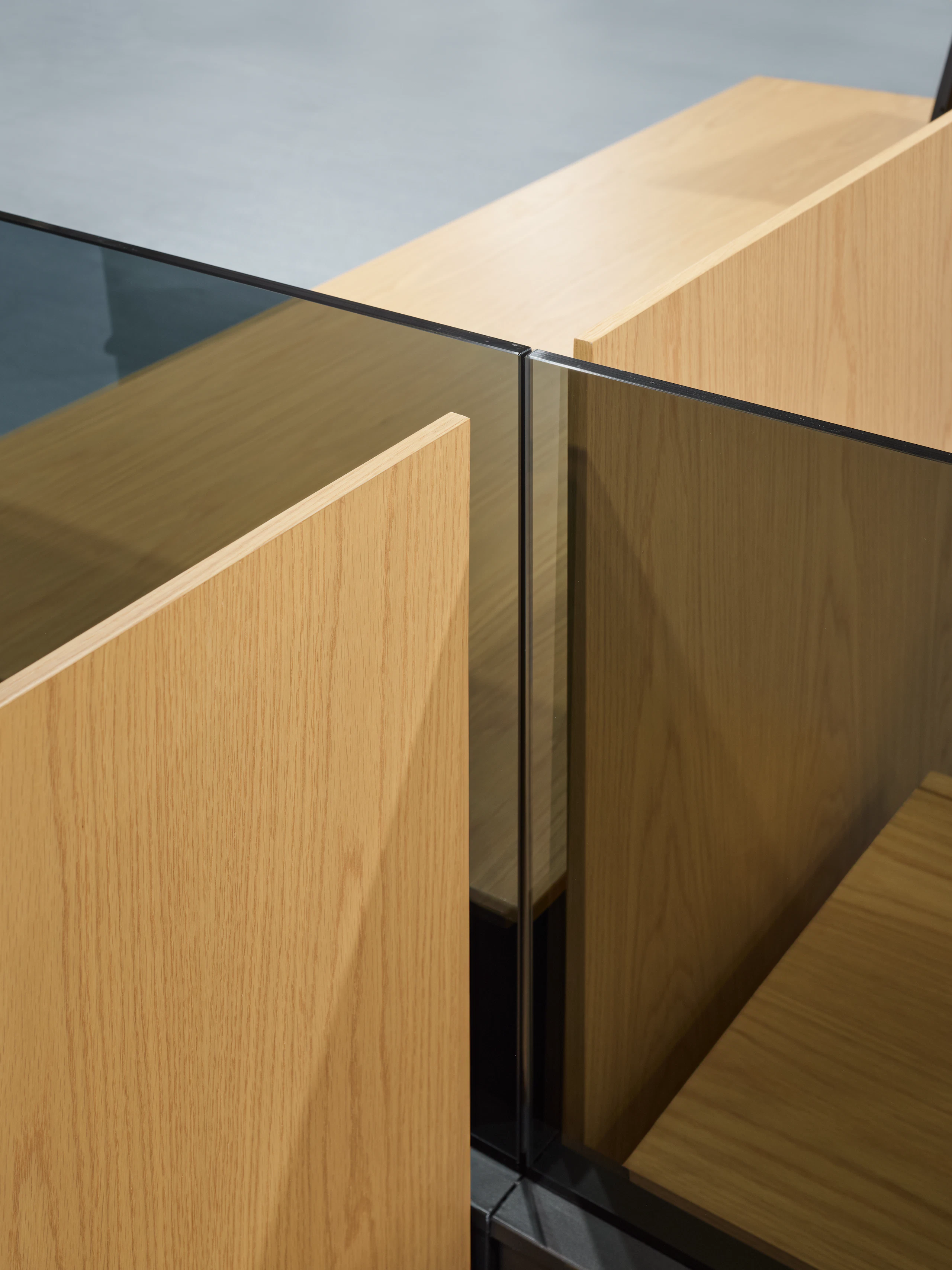 A detail view shows the intersection of workstations separated by glass add ups and veneer screens that intersect perpendicular to one another.