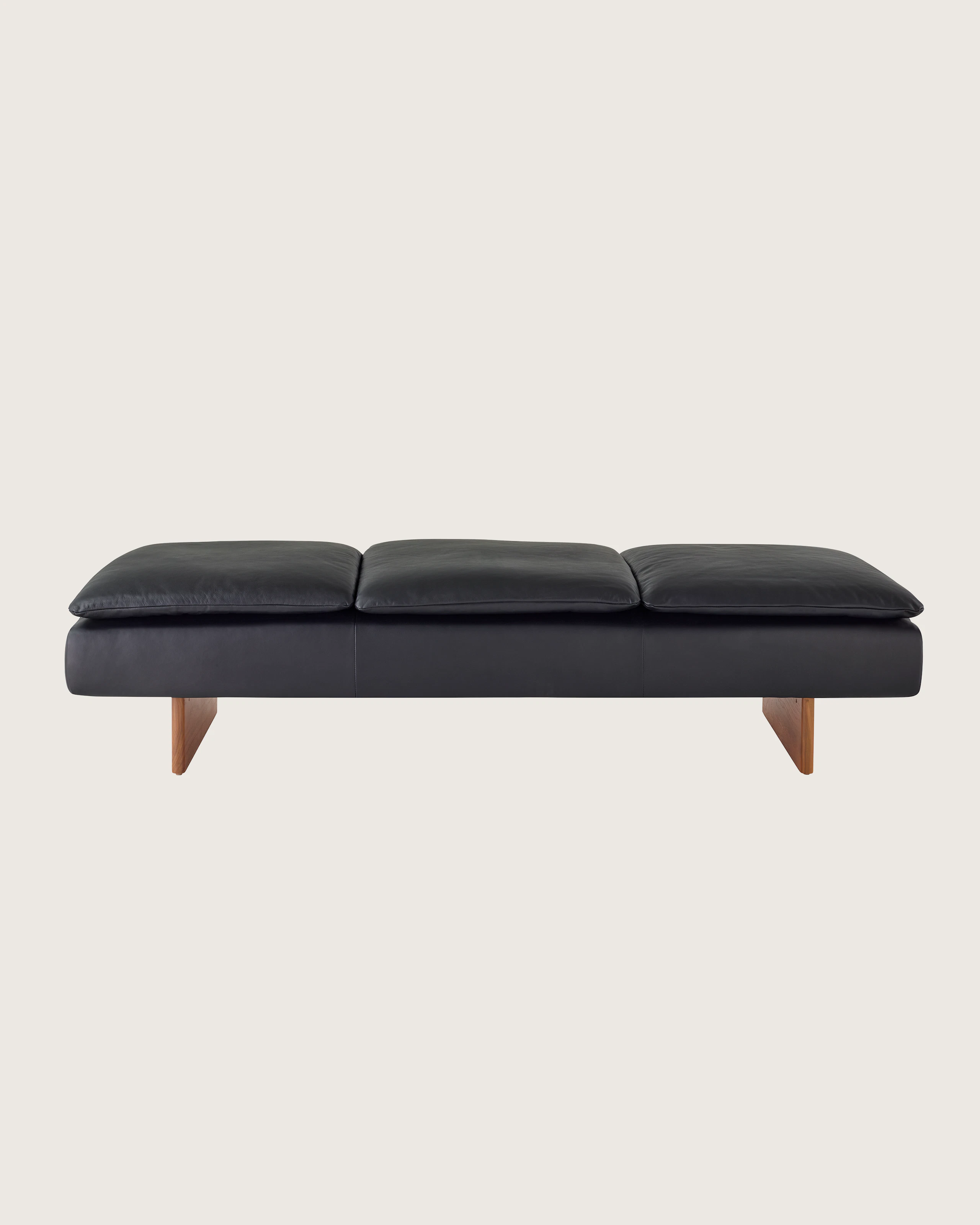 Mantle Three Seater Bench in Black Leather with a Walnut Base, viewed from the front.