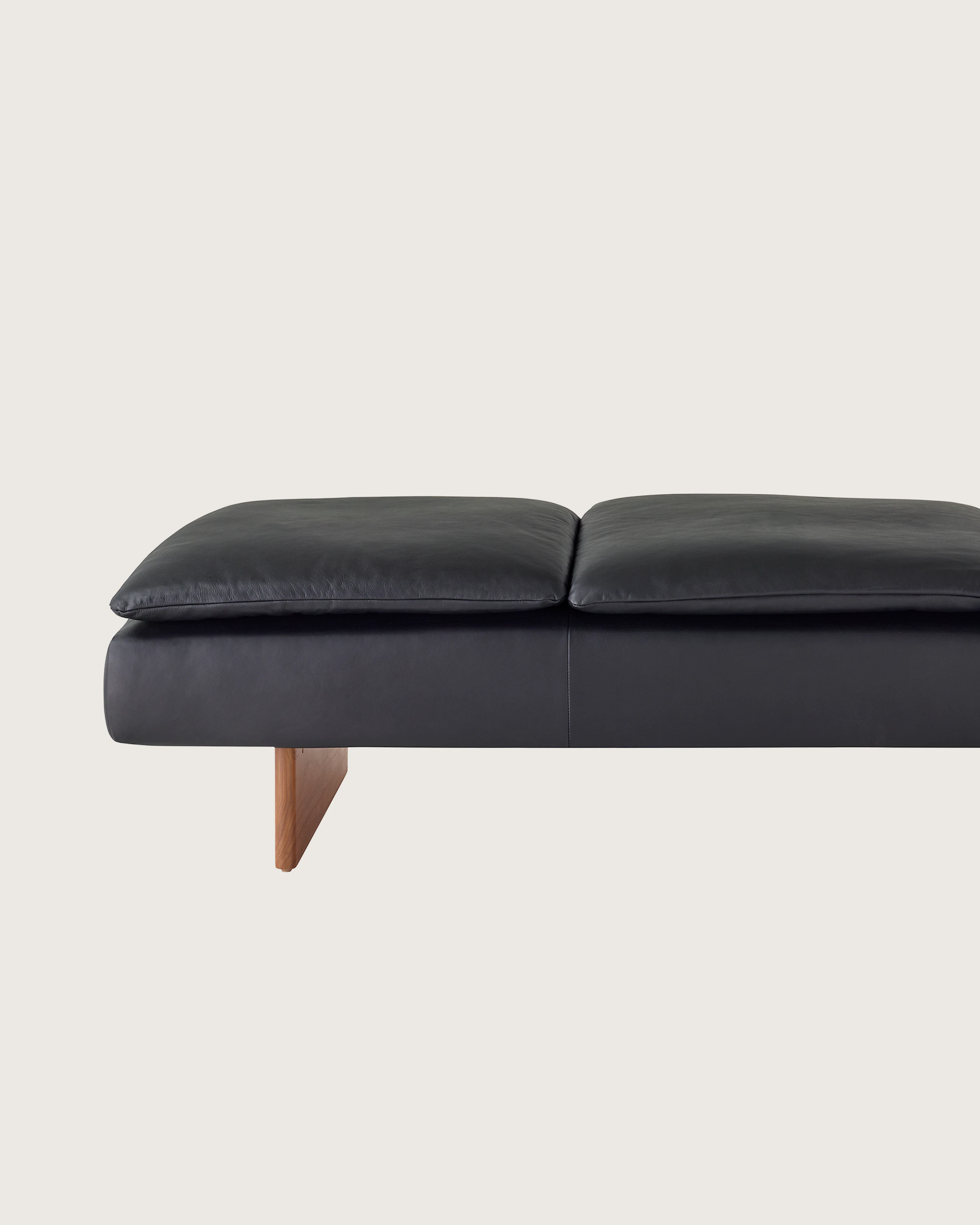 Mantle Three Seater Bench in Black Leather with a Walnut Base, viewed from the front.