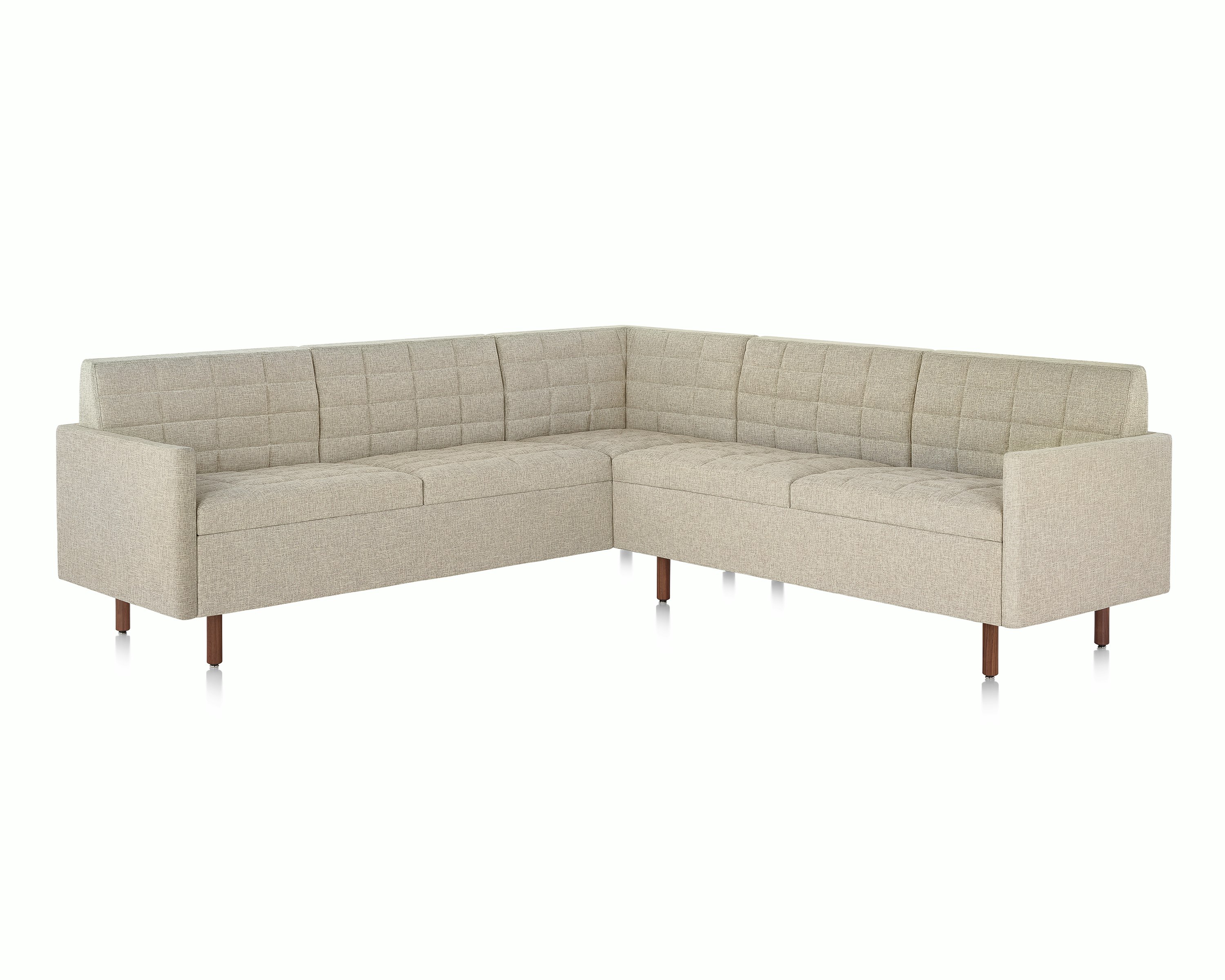 A quilted Tuxedo Classic sectional upholstered in bone-colored fabric.