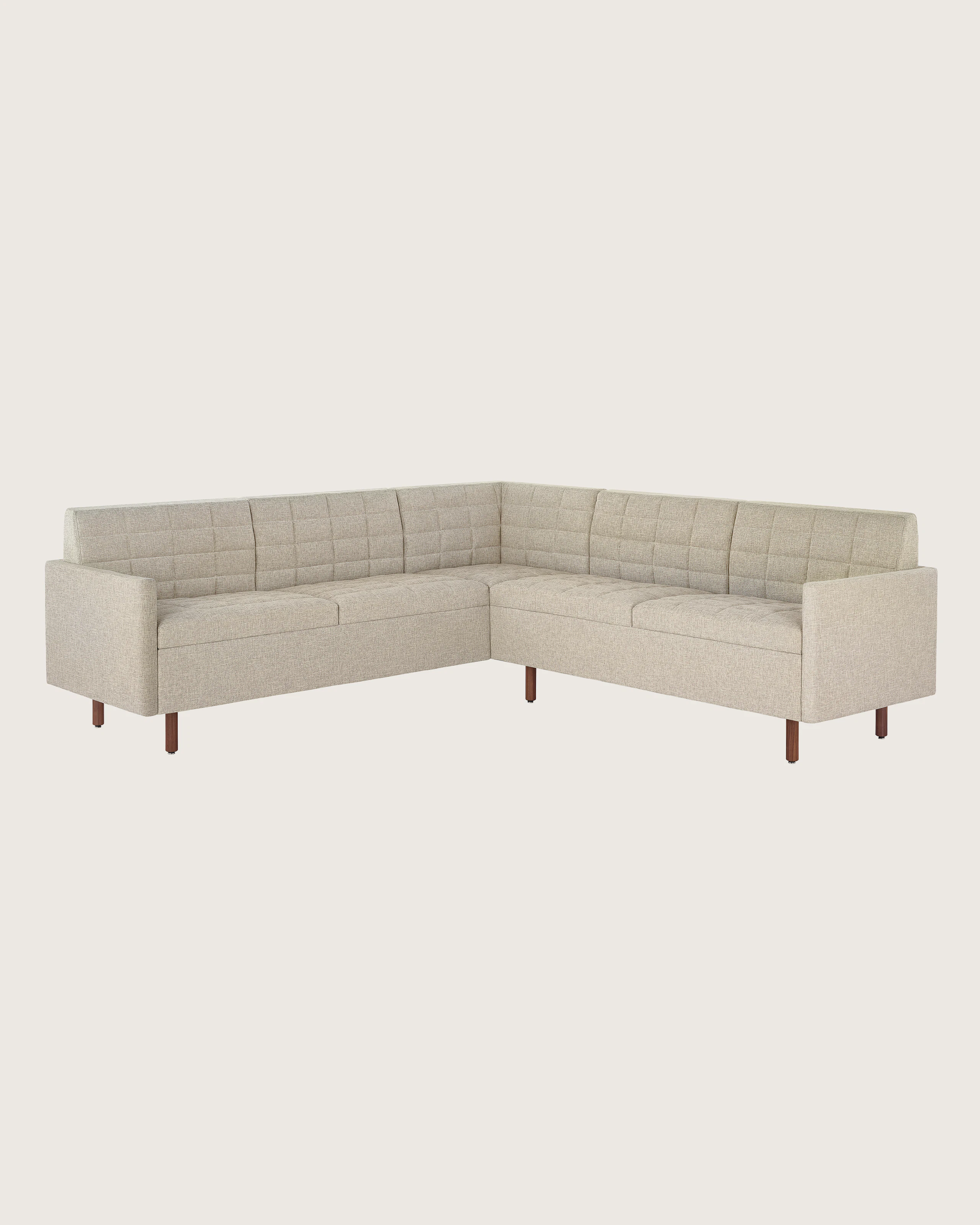 A quilted Tuxedo Classic sectional upholstered in bone-colored fabric.