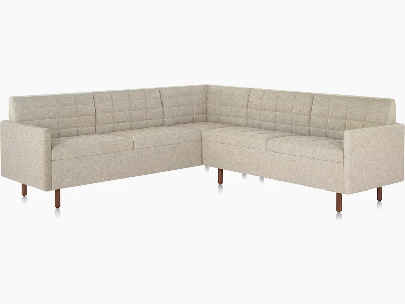 A quilted Tuxedo Classic sectional upholstered in bone-colored fabric.