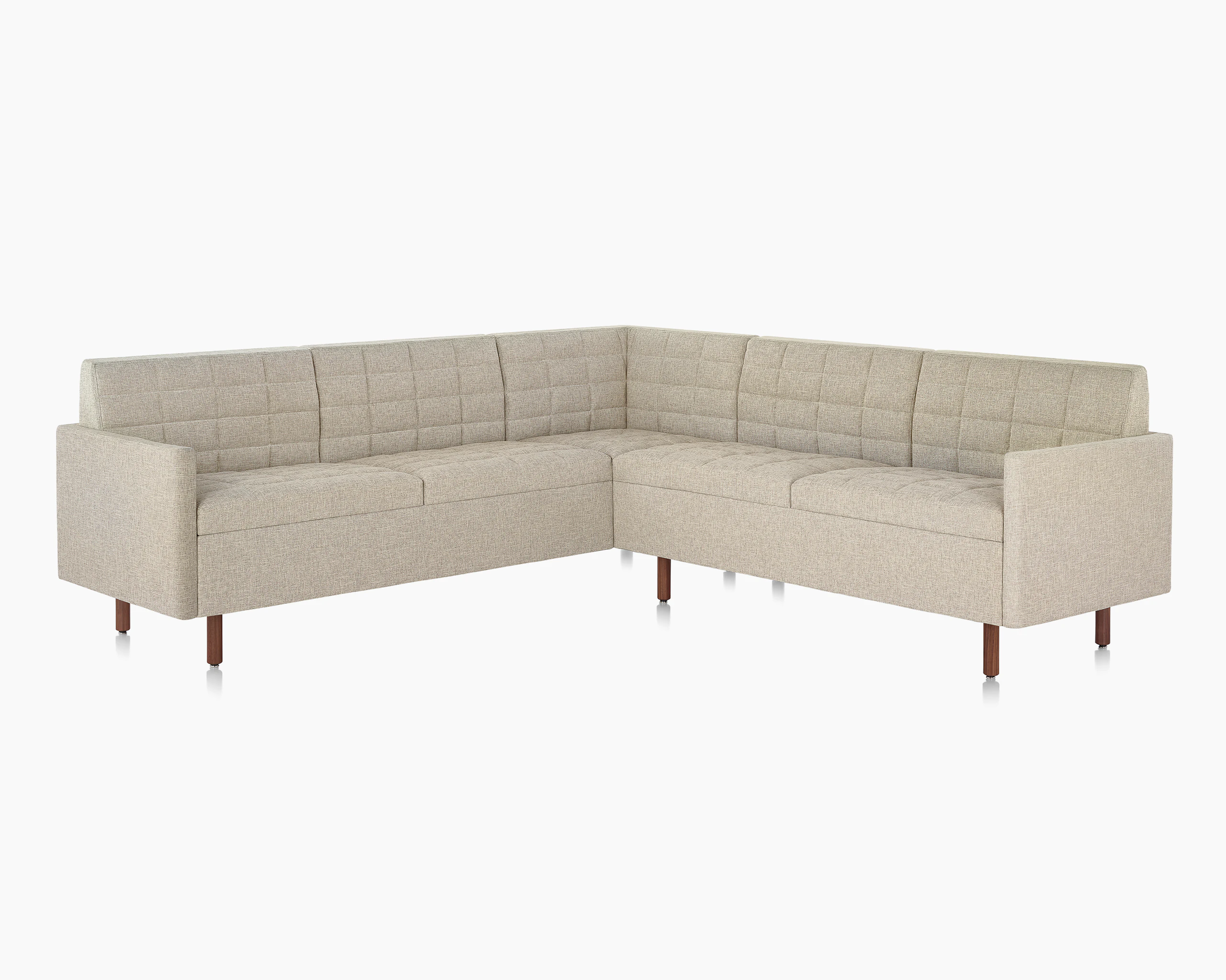A quilted Tuxedo Classic sectional upholstered in bone-colored fabric.