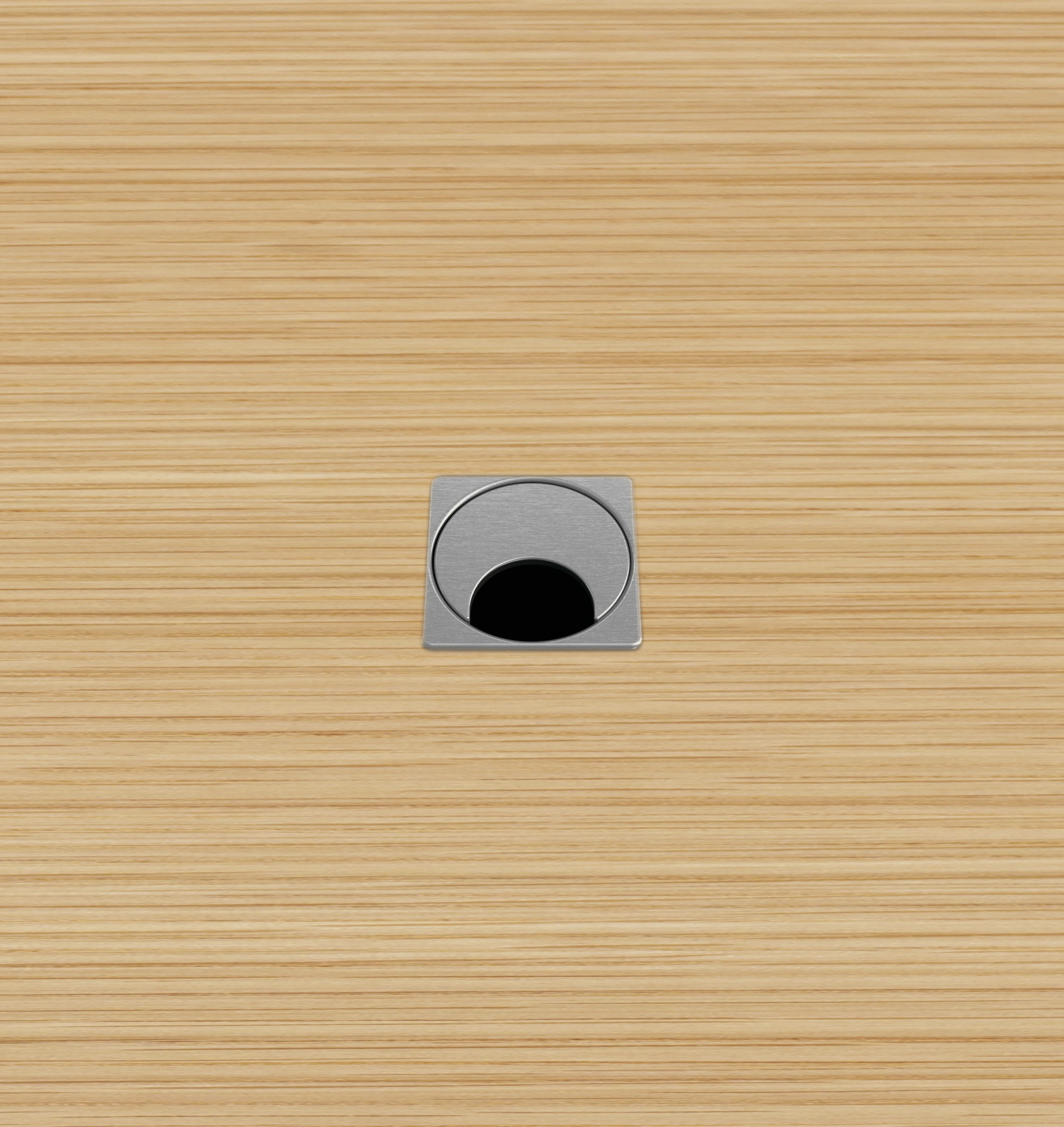 Close-up of the MP Small grommet option for MP Height-Adjustable Tables, which is square with a rotating half-moon opening for cables.