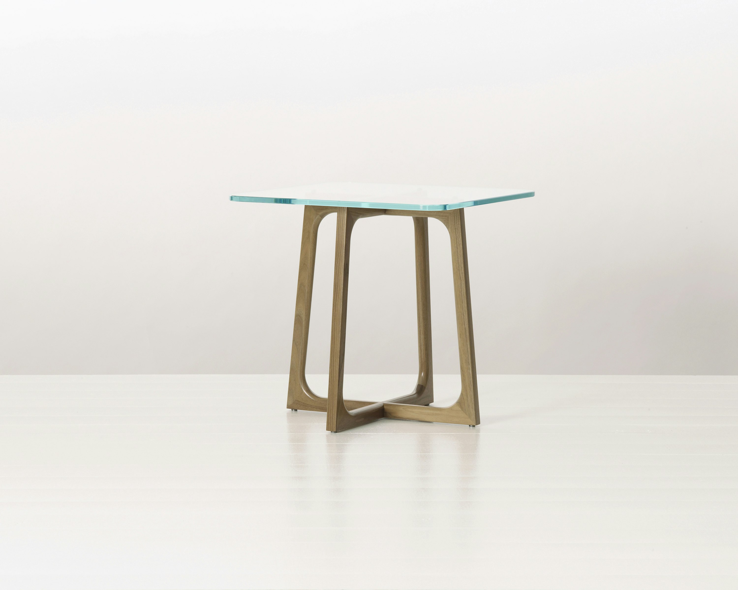 A square Loophole side table with a glass top and walnut base.