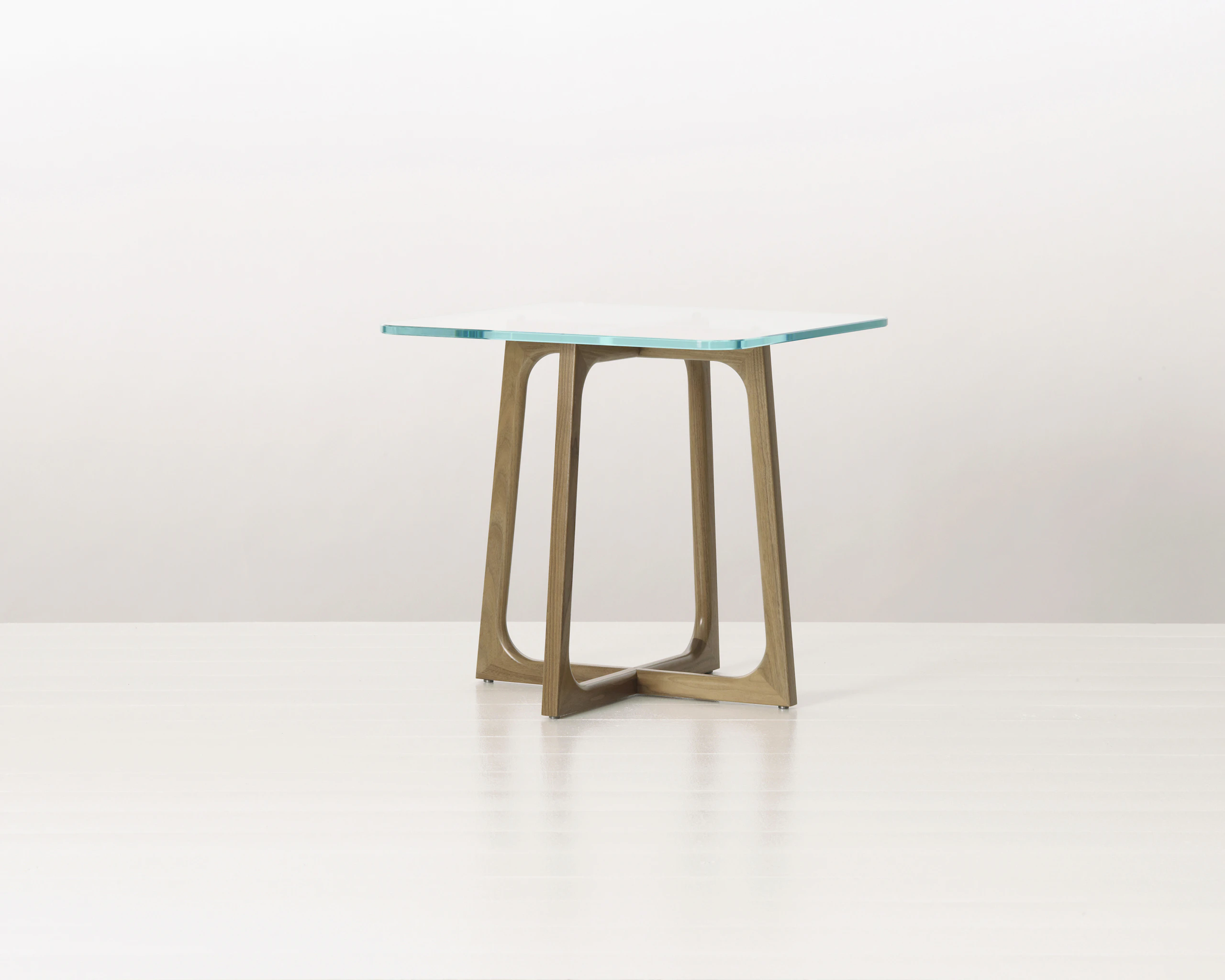 A square Loophole side table with a glass top and walnut base.