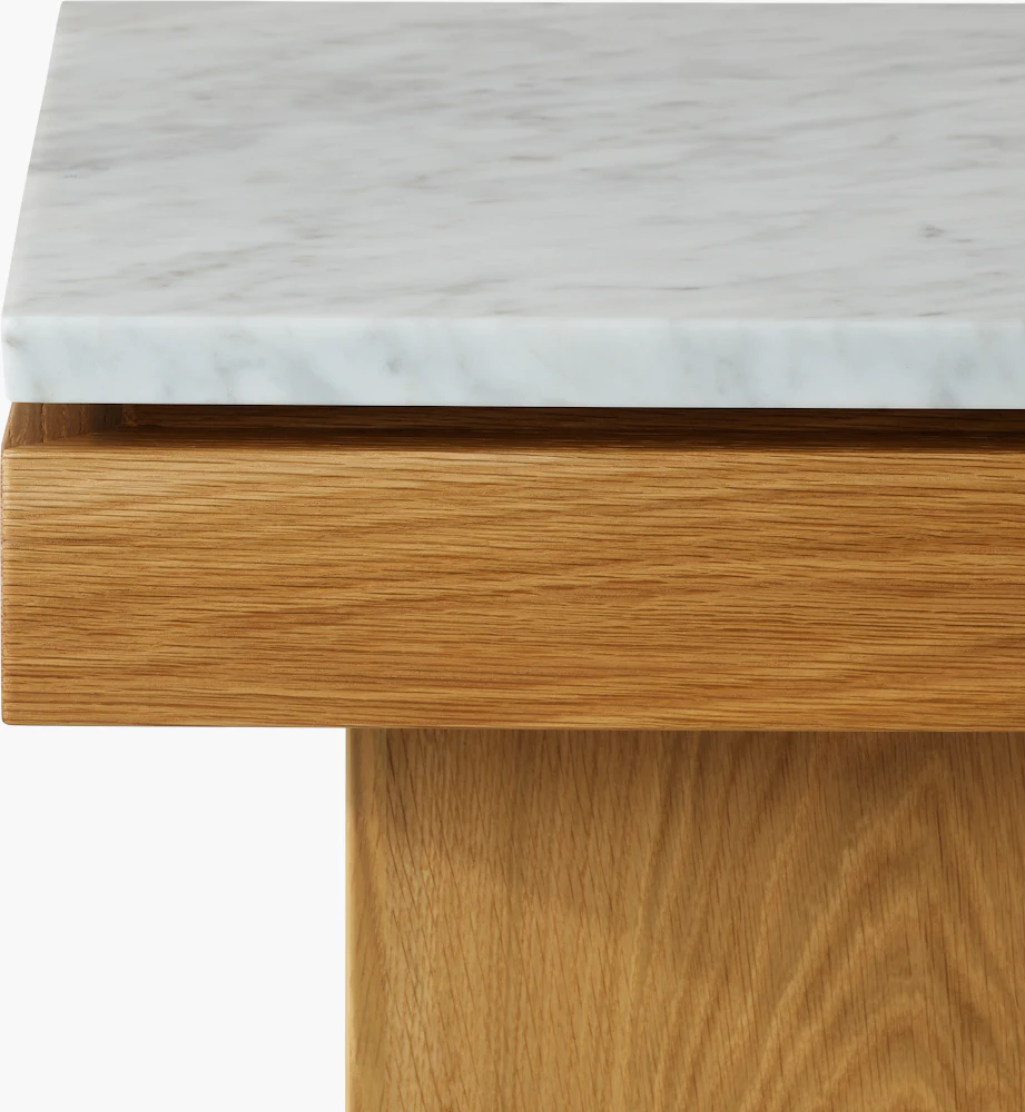 Close-up of marble top and wooden base of table.