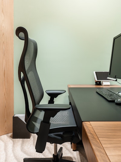 Close up of a Cosm Chair in front of a Leatherwrap Sit-to-Stand Desk.
