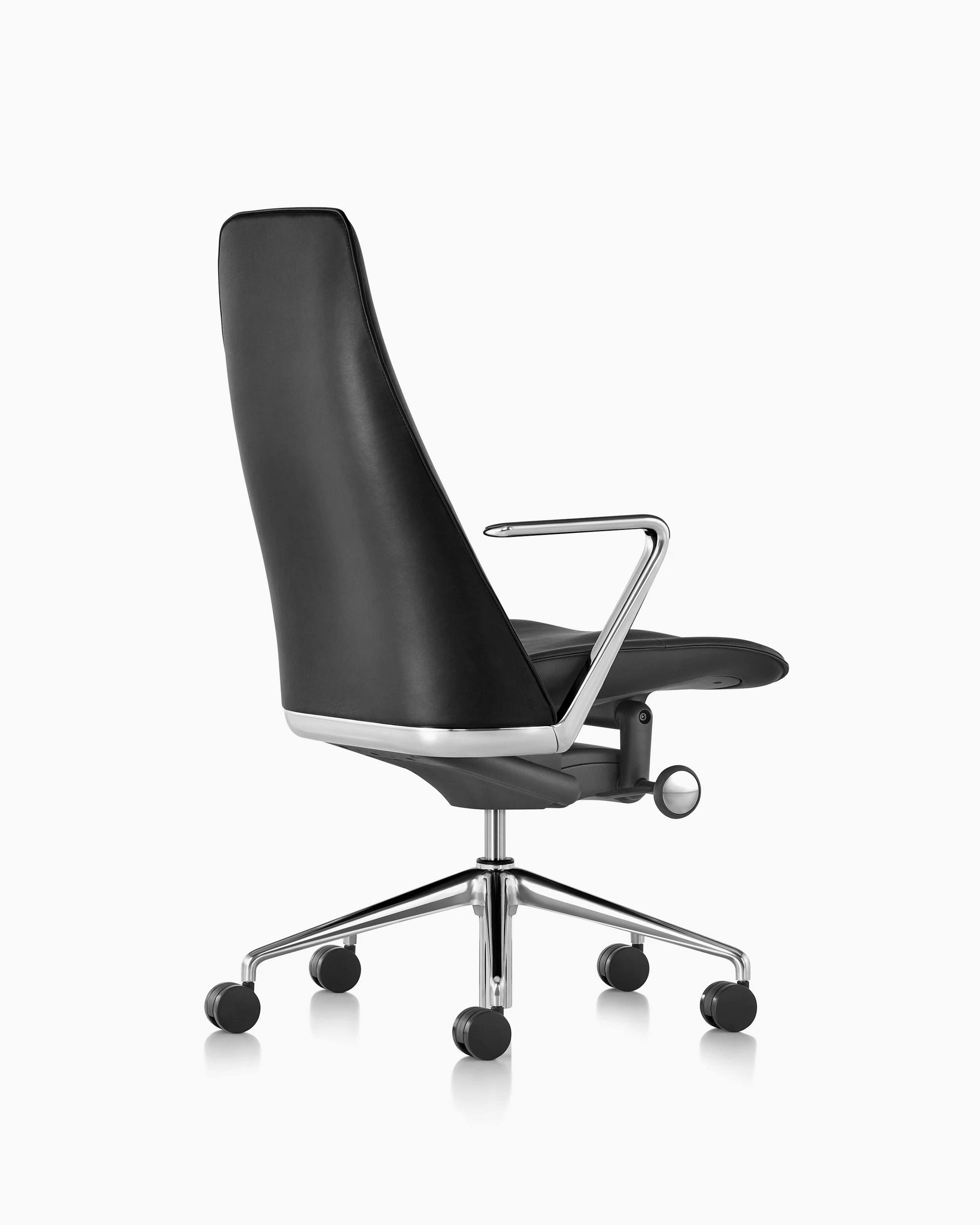The seat, arm, and lower back of a black leather Taper office chair, viewed from behind at an angle.