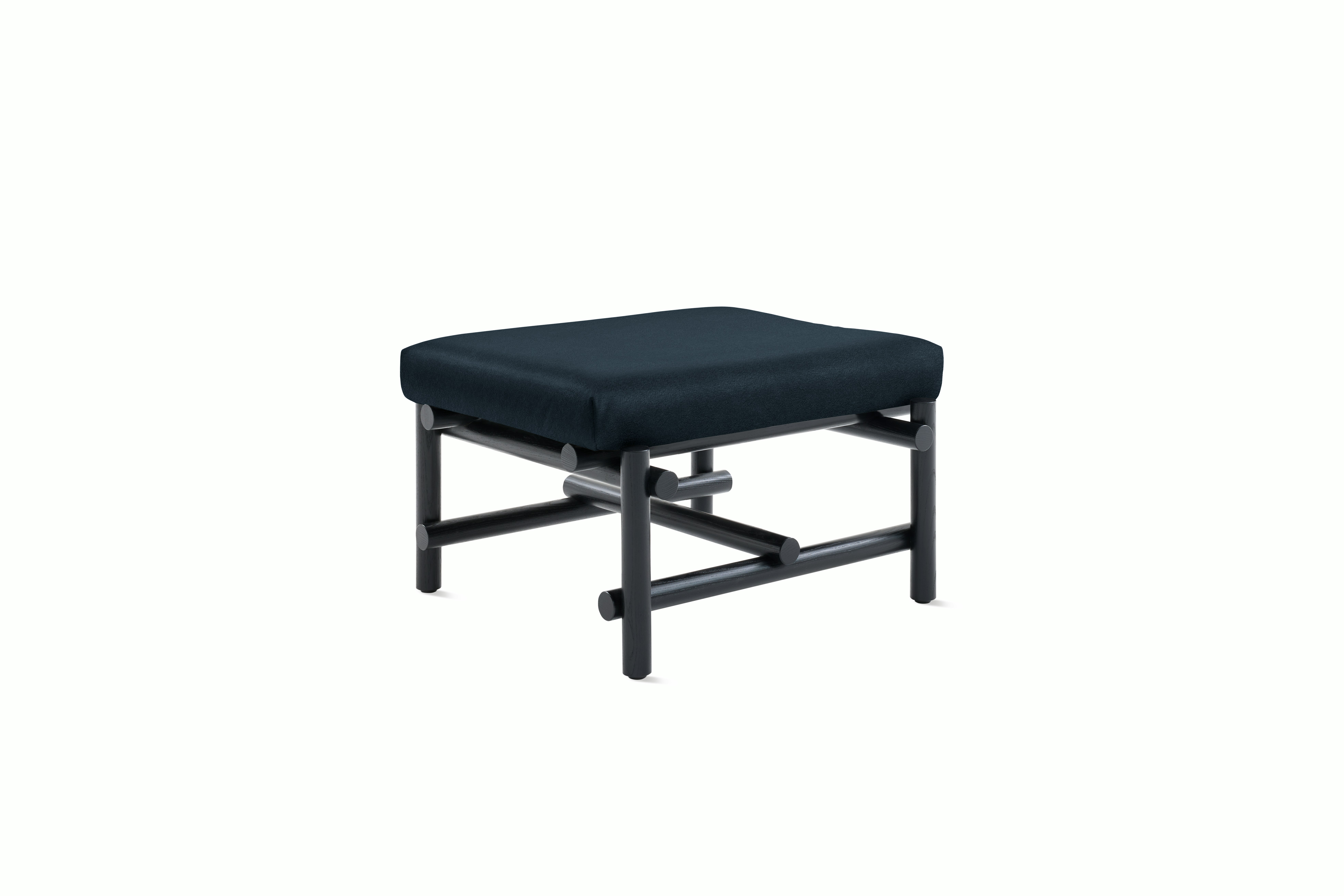 A Muecke Ottoman in Dark Blue Ebonized Ash viewed from an angle.