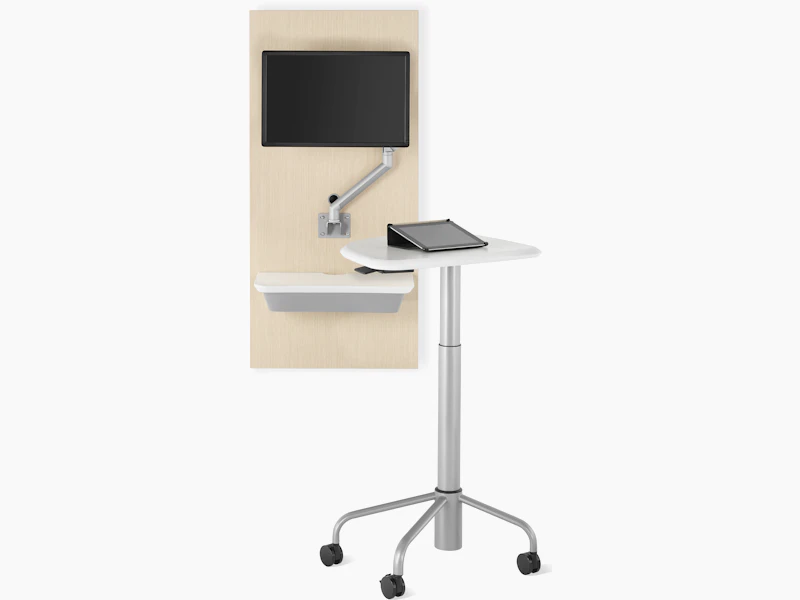 An Intent Solution technology support wall unit in an ash wood finish with an Intent Solution mobile, height-adjustable table.