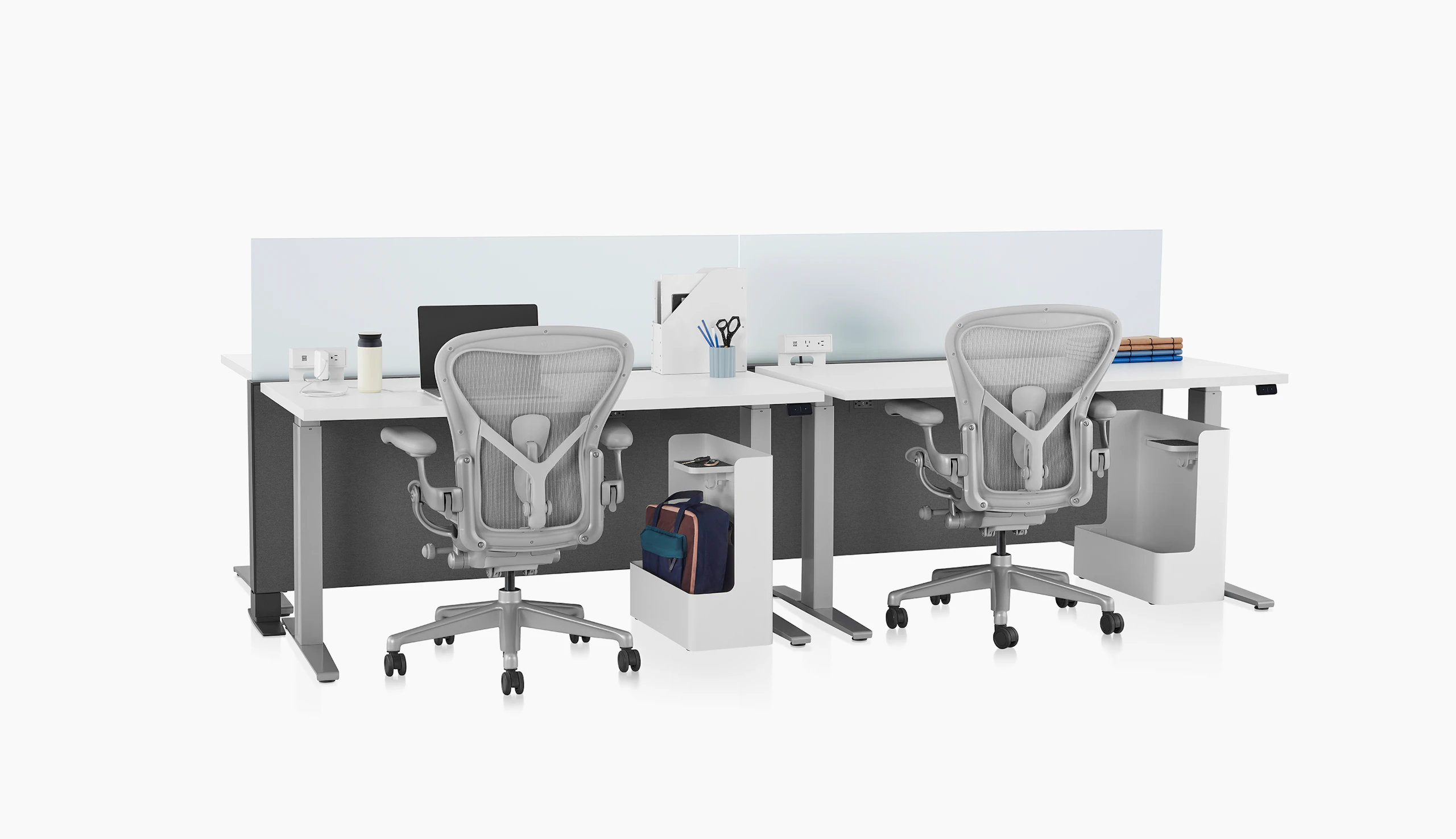 Gray Canvas Channel with glass screens, white Motia Sit-to-Stand Tables, lower bag storage, and light gray Aeron Chairs