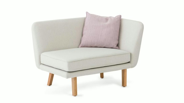 Rockwell Unscripted Modular lounge chair by Knoll with wraparound arms, wooden legs, and a pink accent pillow.