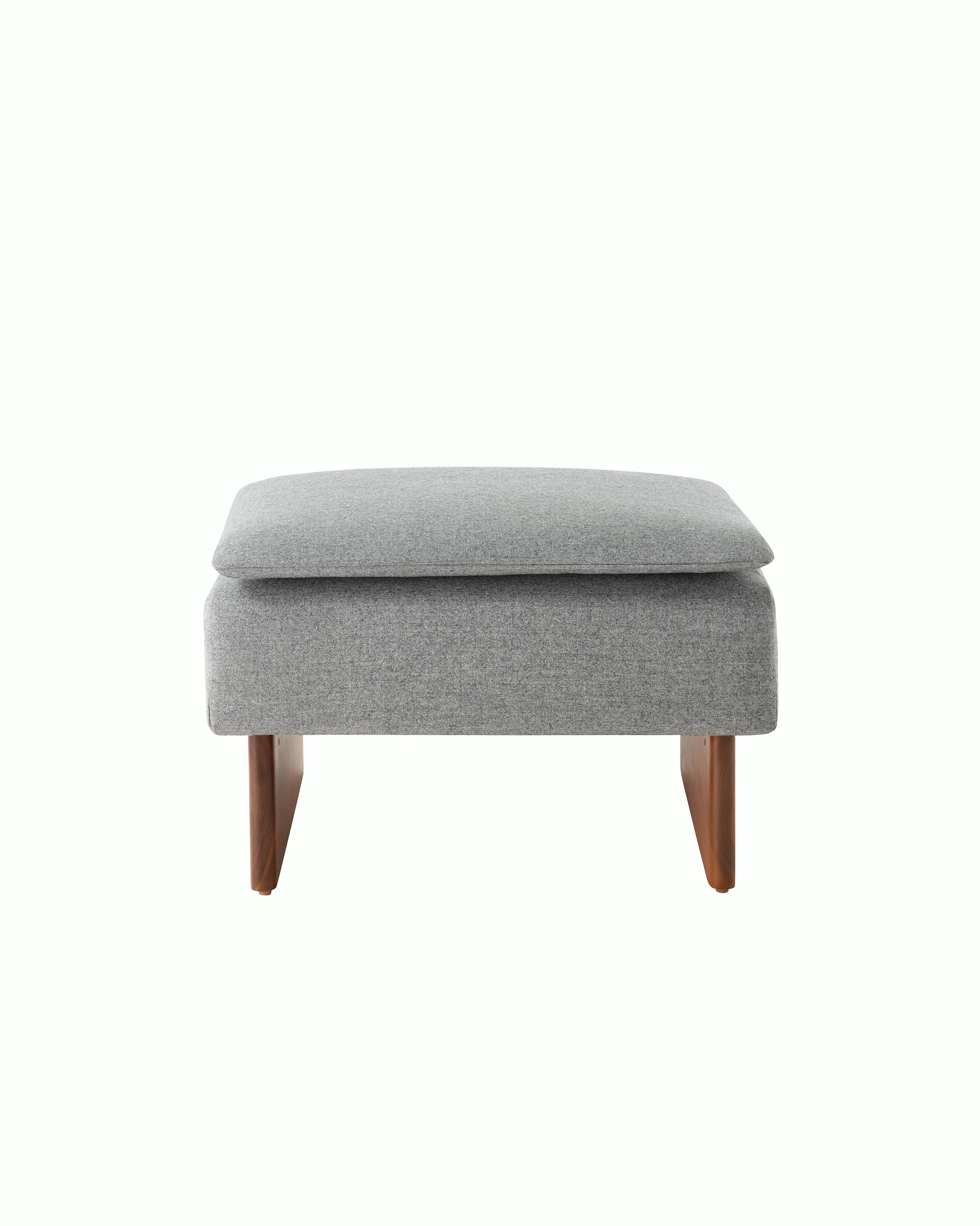 Mantle Ottoman in Panno di Dolce Flannel with a Walnut Base, viewed from the front.