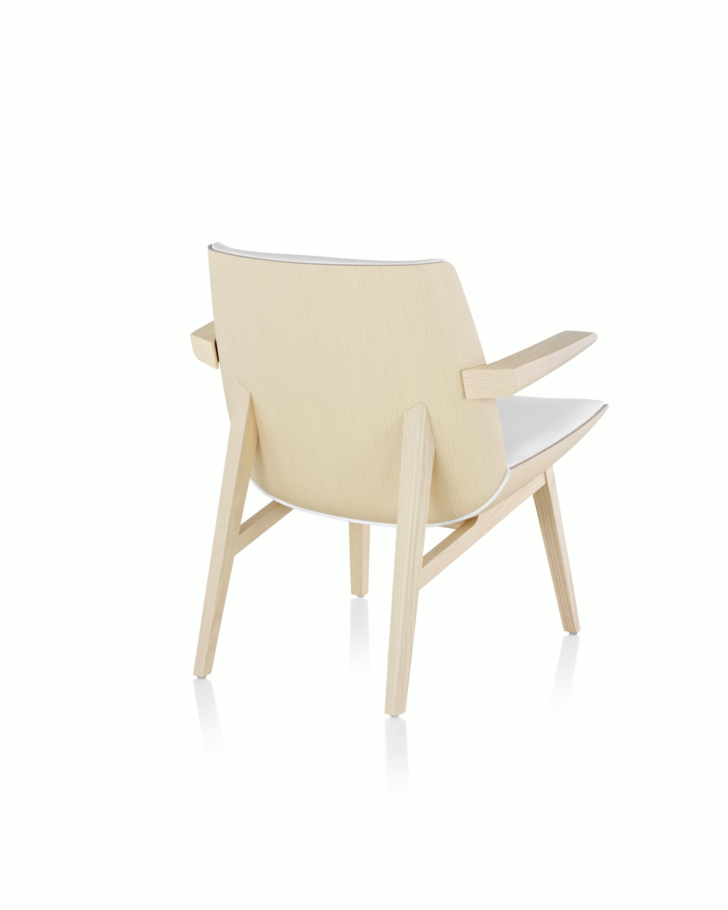 Angled view of a low-back Clamshell Lounge Chair with off-white fabric upholstery and light-ash legs.