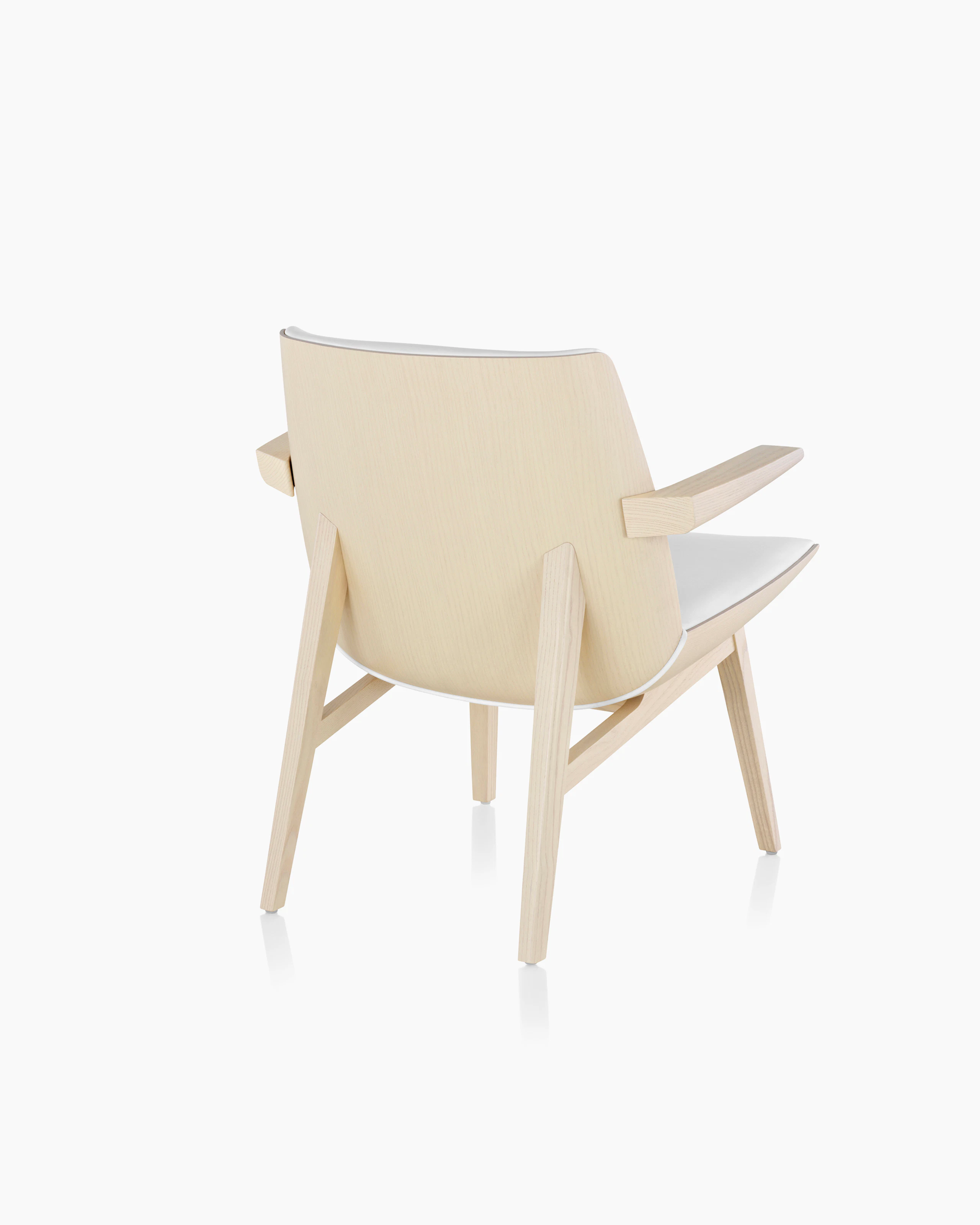 Angled view of a low-back Clamshell Lounge Chair with off-white fabric upholstery and light-ash legs.