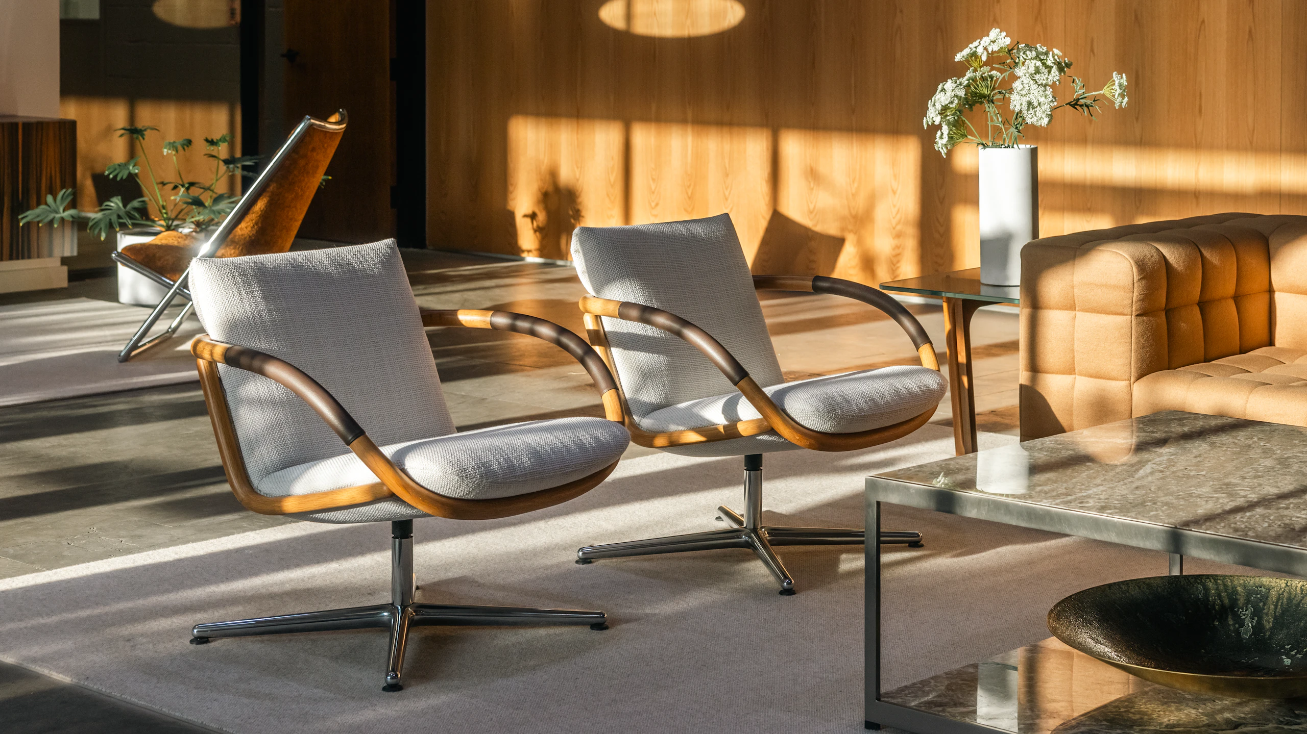 Lounge setting featuring Two Full Loop Lounge Chairs, an H Frame Coffee Table, and a Rapport Sofa viewed from an angle in a showroom.