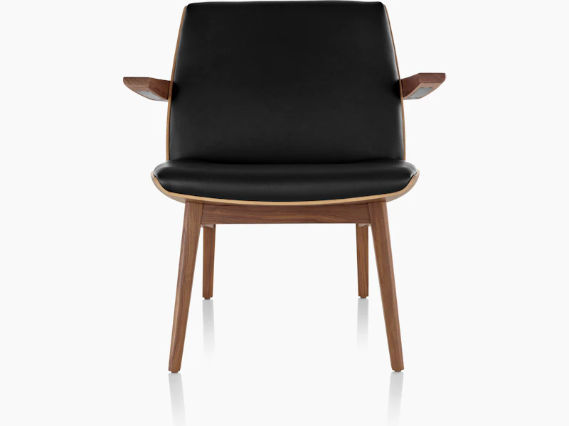 Front view of a low-back Clamshell Lounge Chair with black leather and walnut legs.