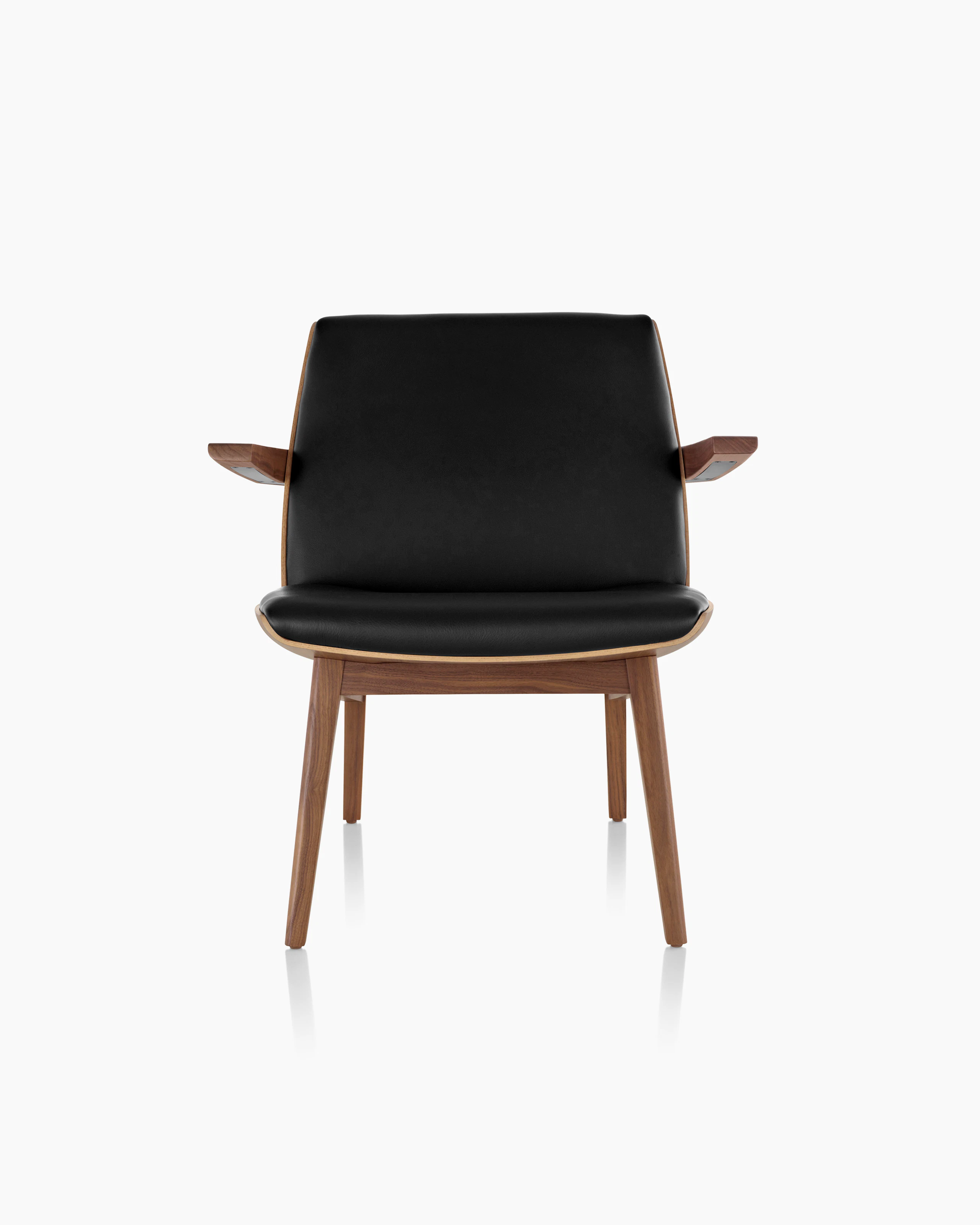 Front view of a low-back Clamshell Lounge Chair with black leather and walnut legs.