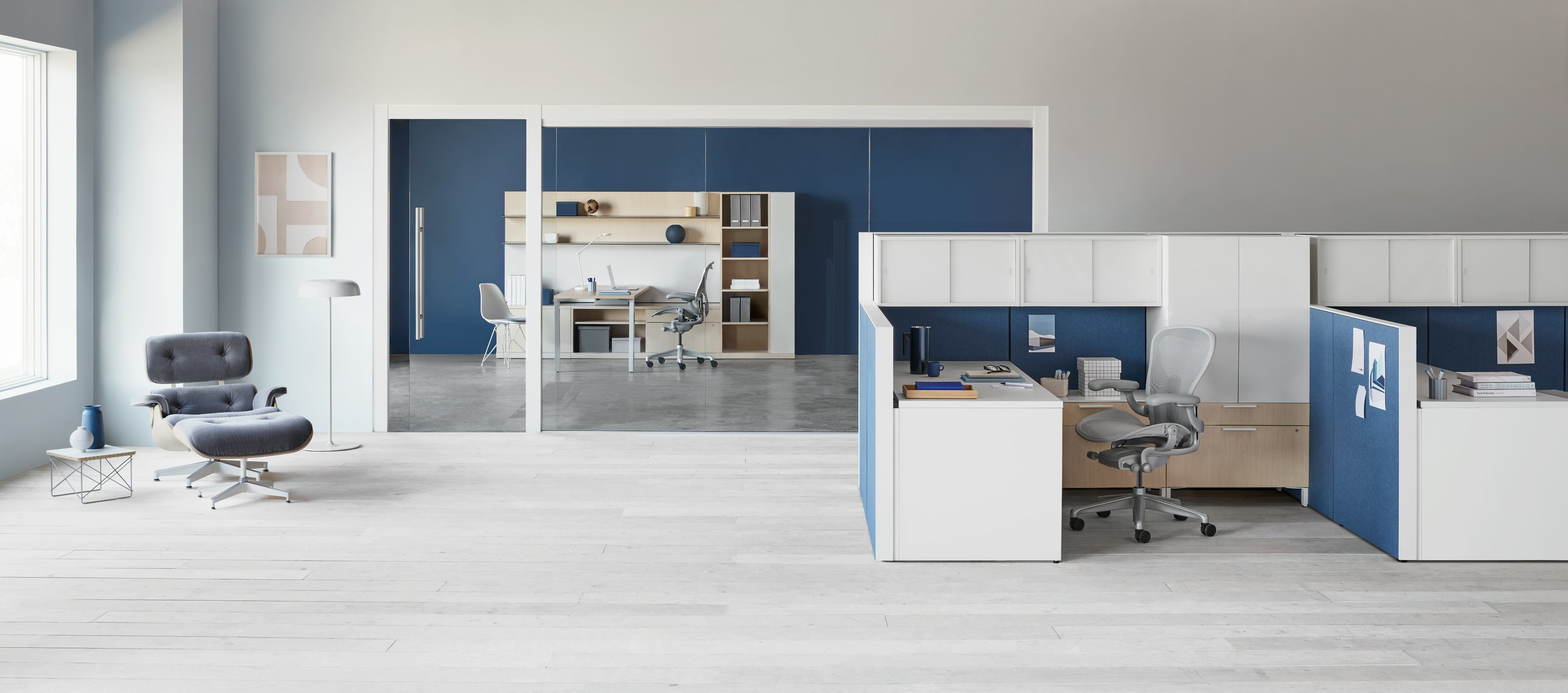 Canvas Wall workstation with blue panels and white overhead storage. Canvas Private Office in the background.