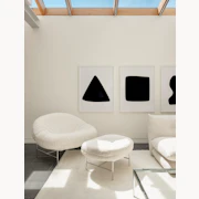 Lounge chairs and ottoman in a minimalist room.