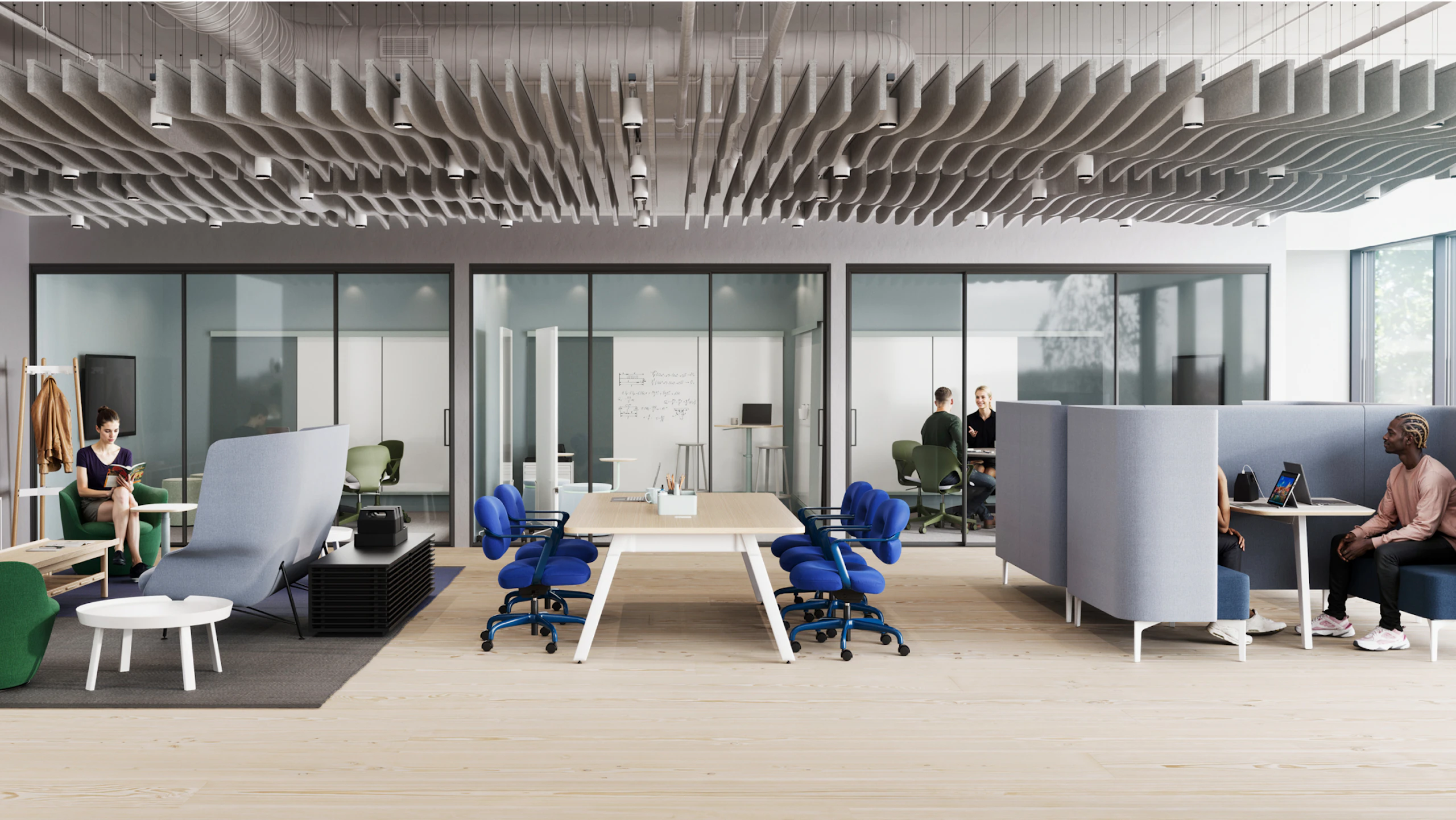 Open-plan learning space with glass walls, wooden flooring, and ceiling panels. Blue chairs surround long tables. Partitioned seating areas occupied by people working on laptops.