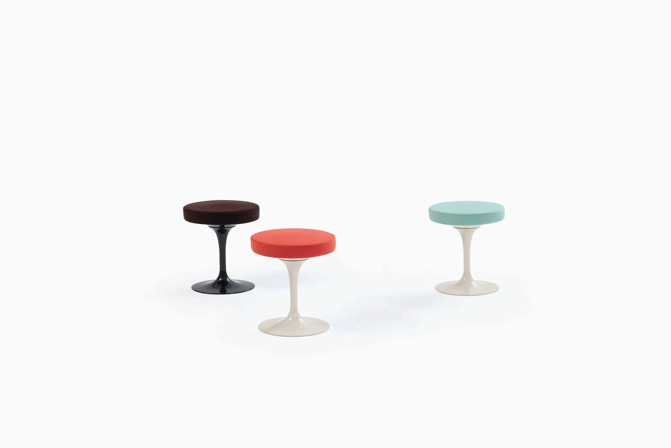 Three Tulip Stools with black, red, and blue seats.