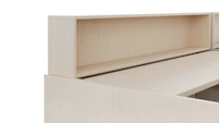 A height adjustable work surface is viewed from an angle. On top of the work surface is a personal storage cubby in a light color veneer.