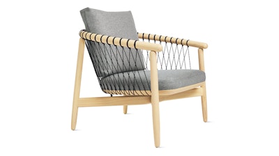 A light wood finish Crosshatch Chair by Geiger with a grey cushion on a white background