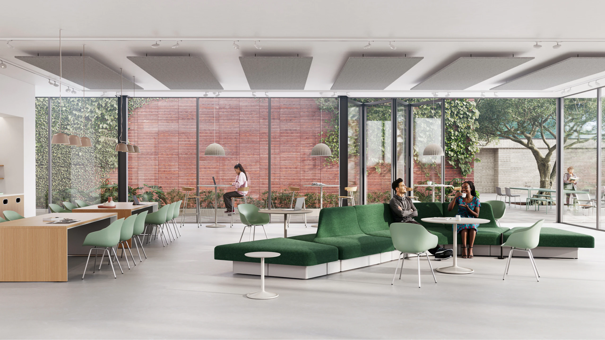 Modern lounge area with green modular sofa, light wood tables, and various seating options. Large windows overlook a green space with trees.