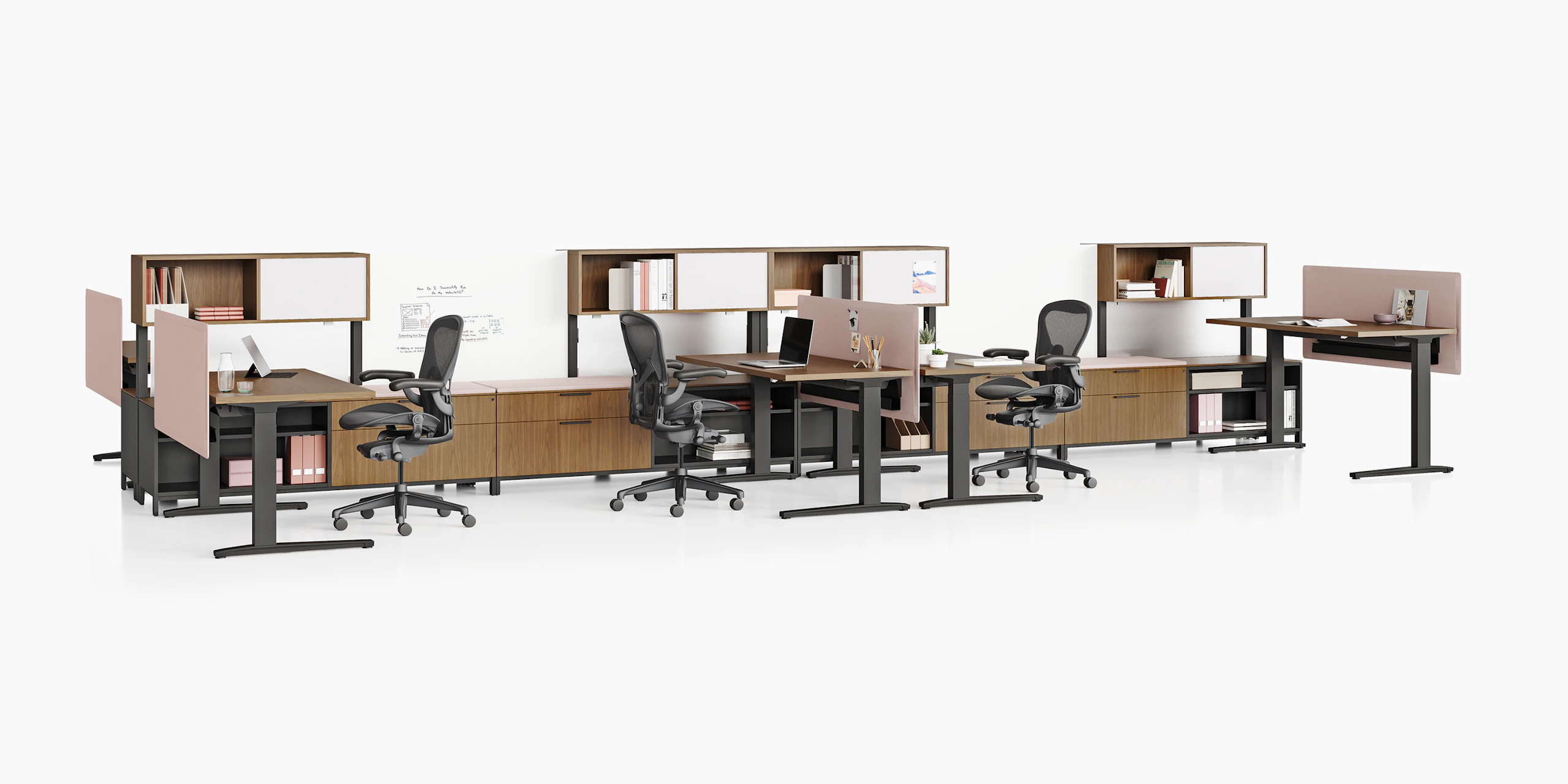 Canvas Dock workstations with sit-to-stand tables, storage, pink screens, and black Aeron Chairs.