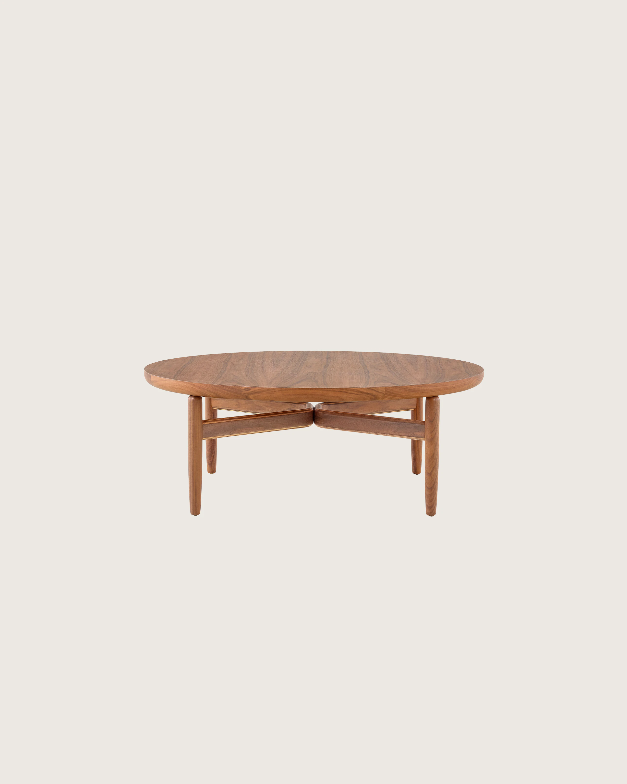 A Reframe Round Table in Walnut, viewed from the side.