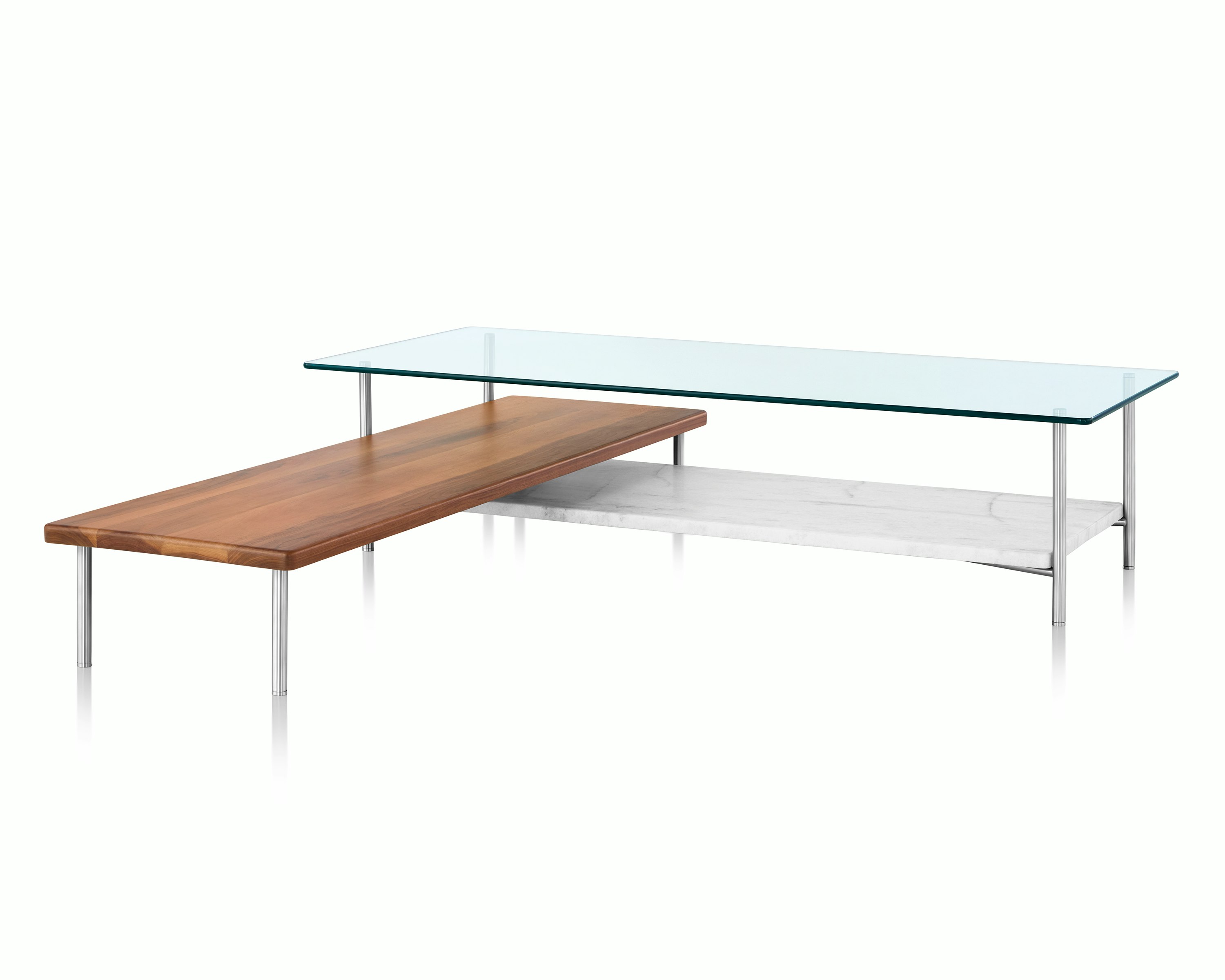 Partial view of an L-shaped Layer coffee table, focusing on the soft corners and cylindrical metal legs.