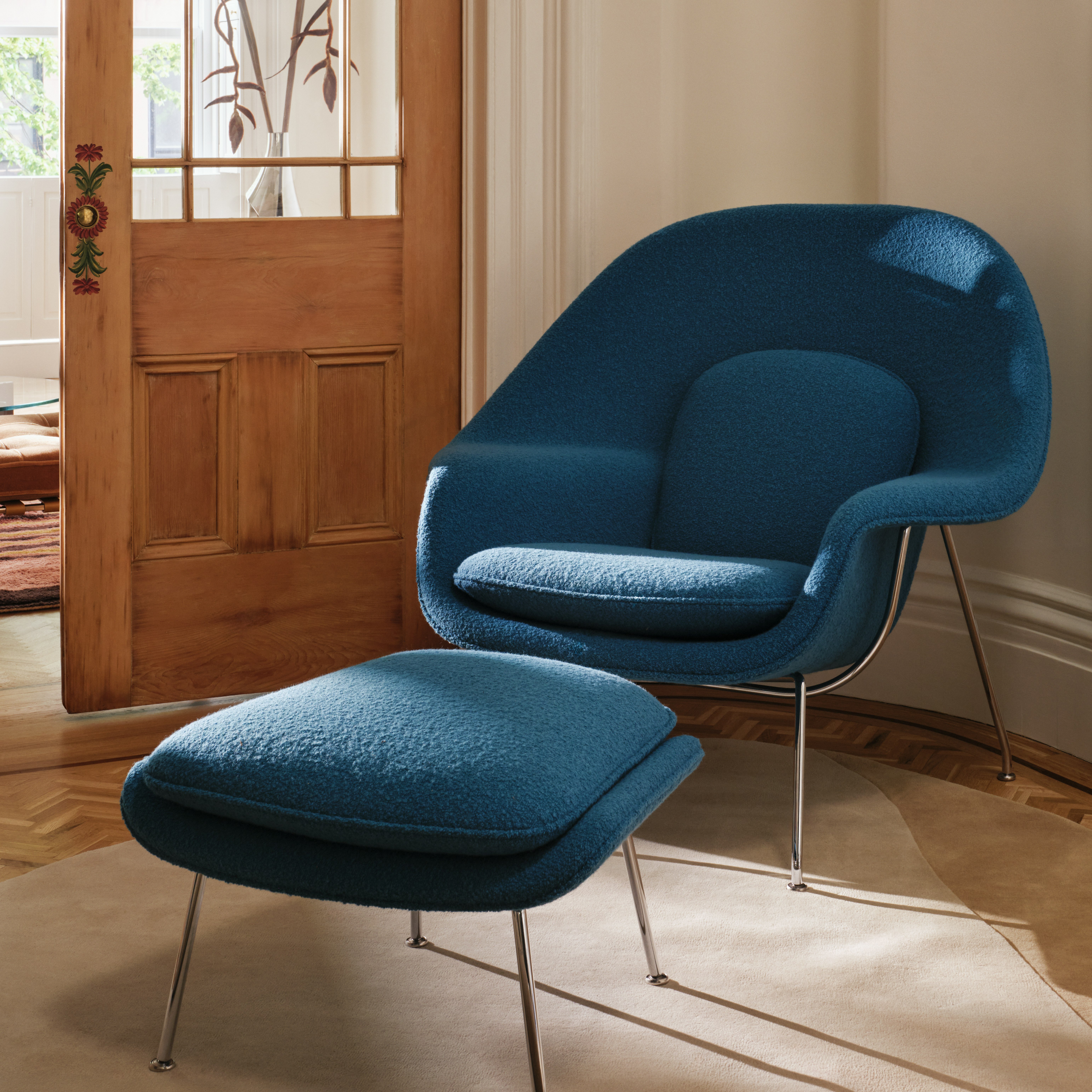 Womb Chair and Ottoman in blue boucle and chrome viewed at an angle