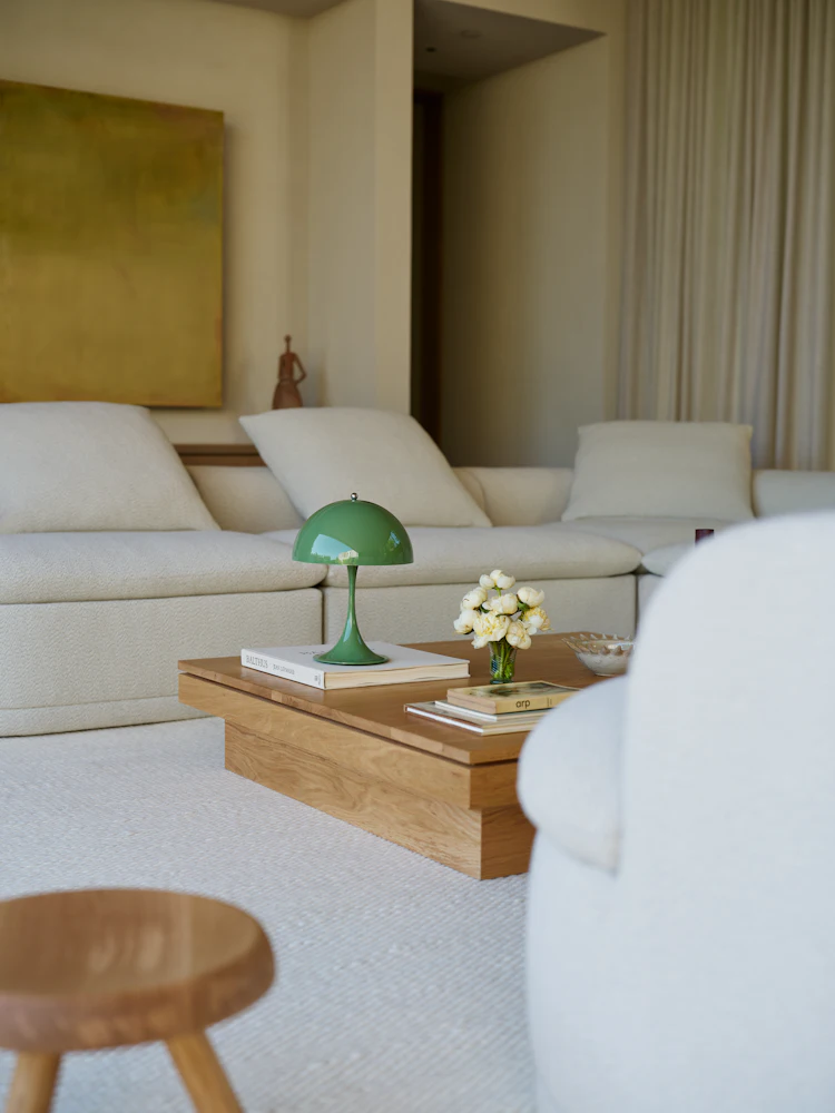 Living room with coffee table and green lamp; closer view of table.