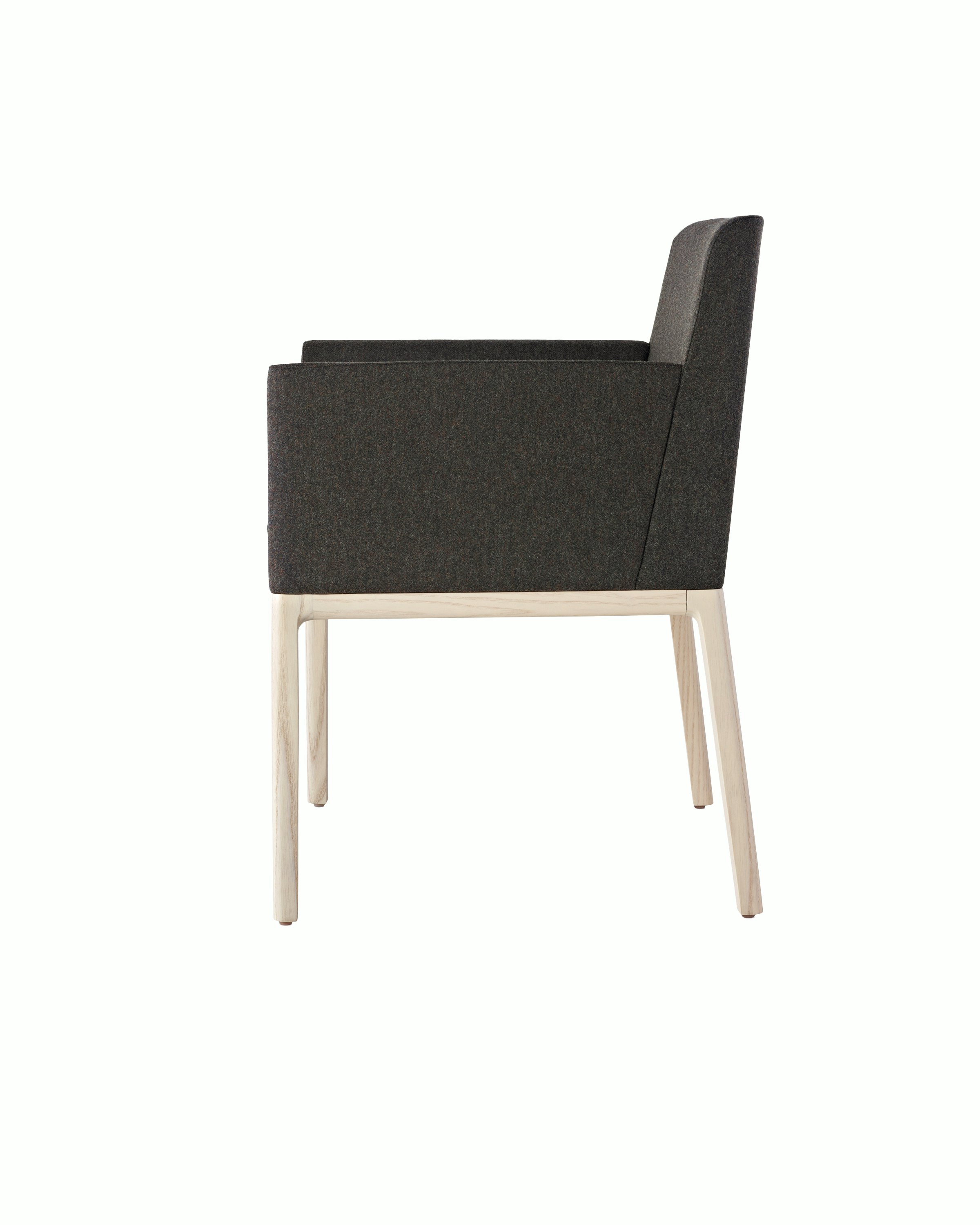 Side view of a Nessel side chair with black fabric upholstery, wraparound arms, and a wood frame with a light finish.