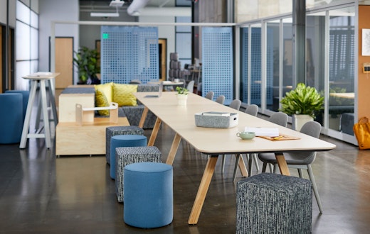 rockwell unscripted library table upholstered seats swivel stools steps laptop tray tall table drink rail creative wall filzfelt hanging panels fixed fins glass assembly community immersive open room muuto fiber side chair hospitality team meeting