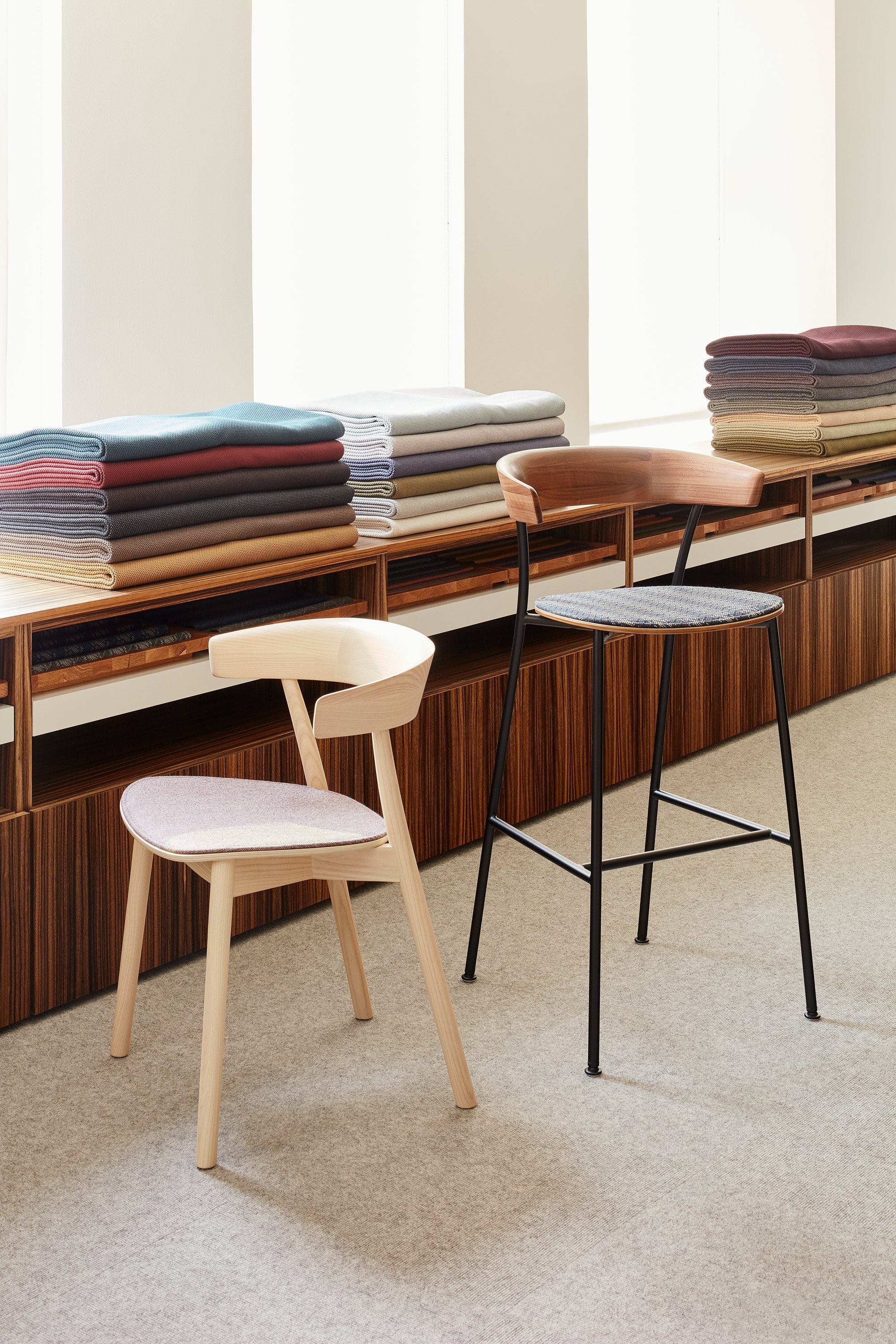 A Leeway Chair and a Leeway Stool sitting in front of a textile display.