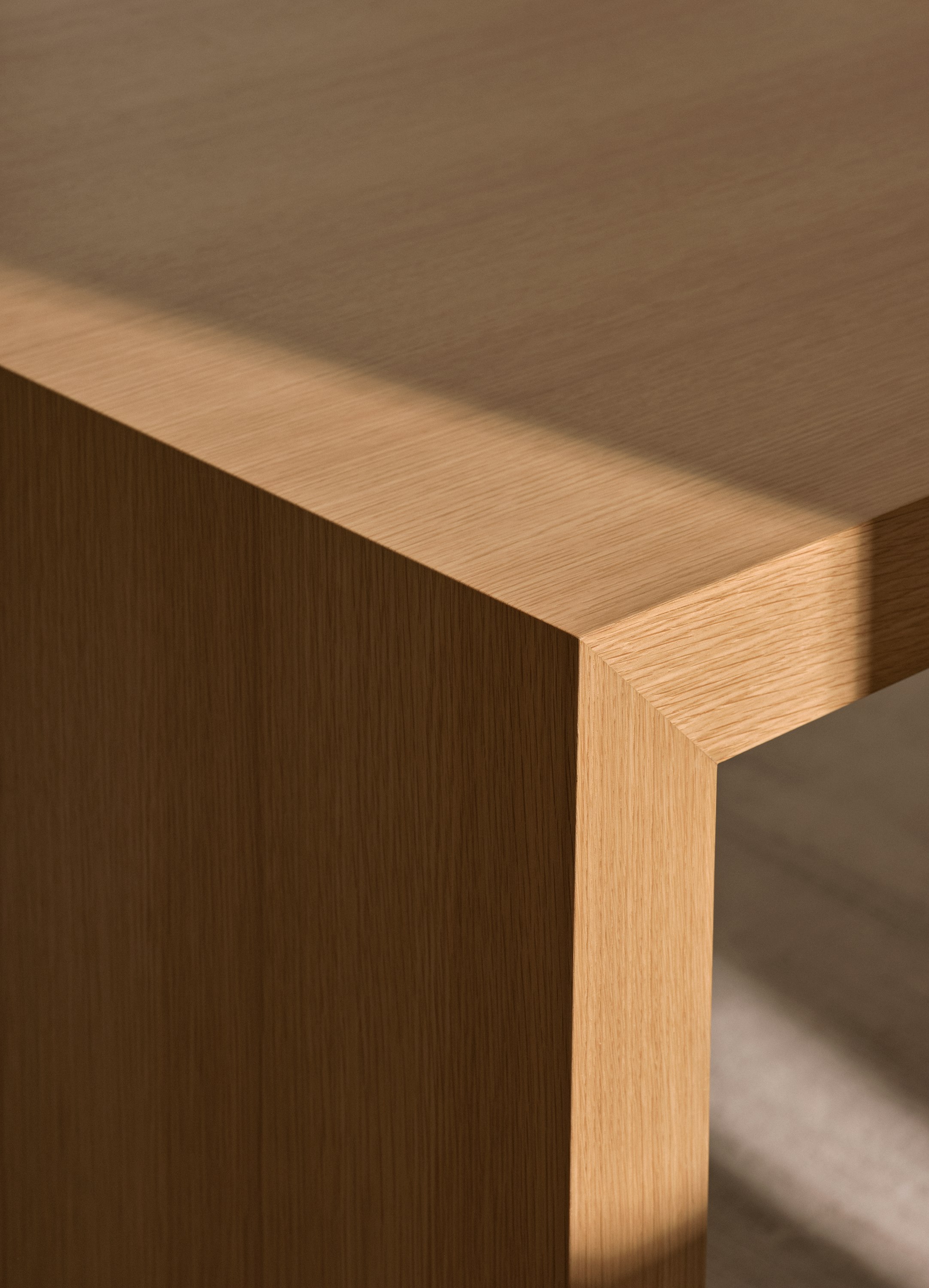 Detail view of a JD Waterfall Table’s mitered edge in Natural Rift Cut Oak, viewed at an angle.