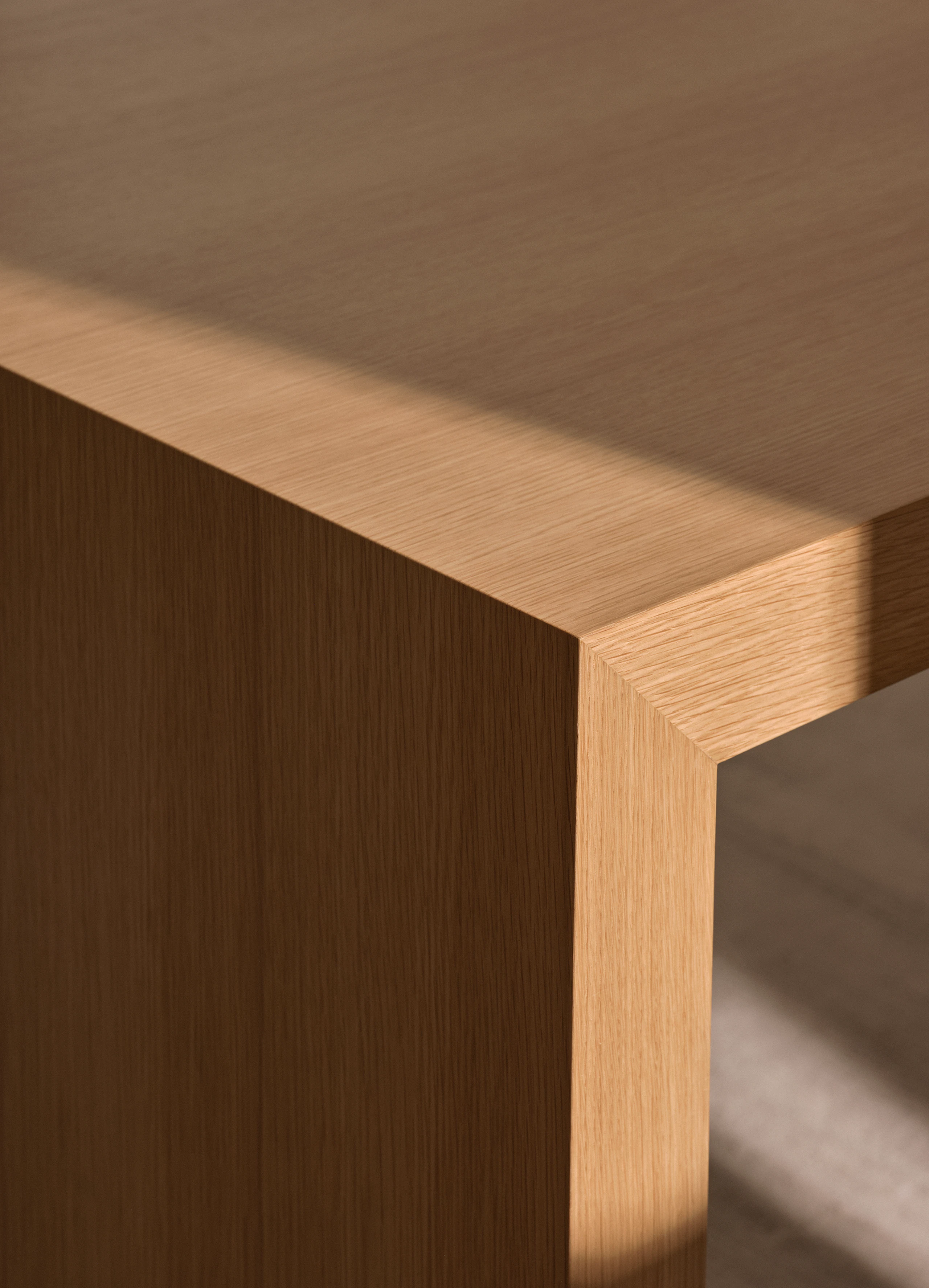 Detail view of a JD Waterfall Table’s mitered edge in Natural Rift Cut Oak, viewed at an angle.