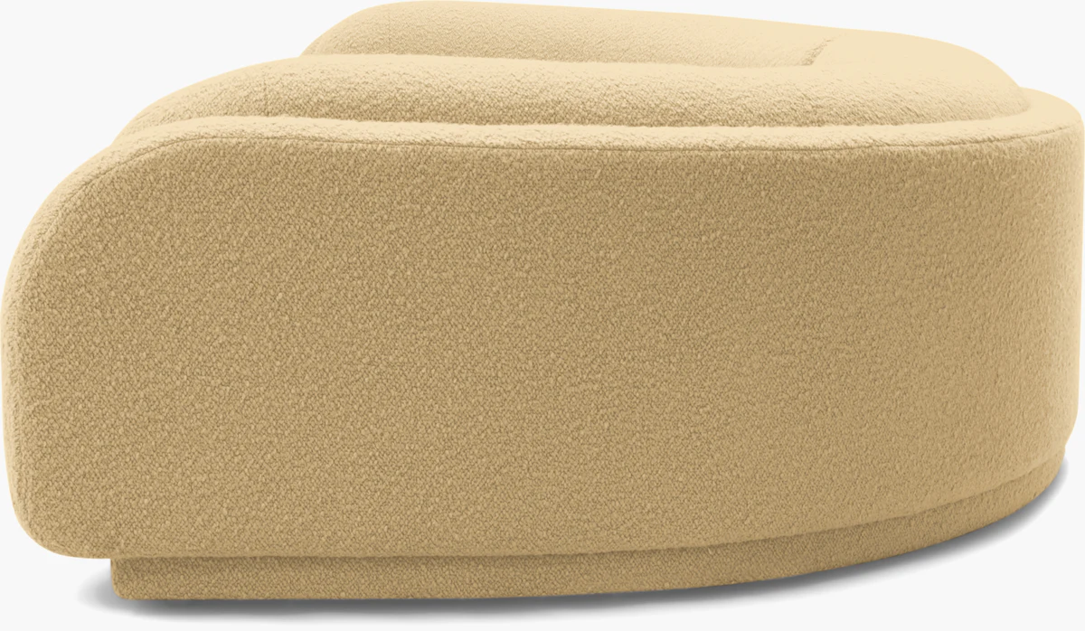 Top-down view of curved beige ottoman/sofa component with plush fabric