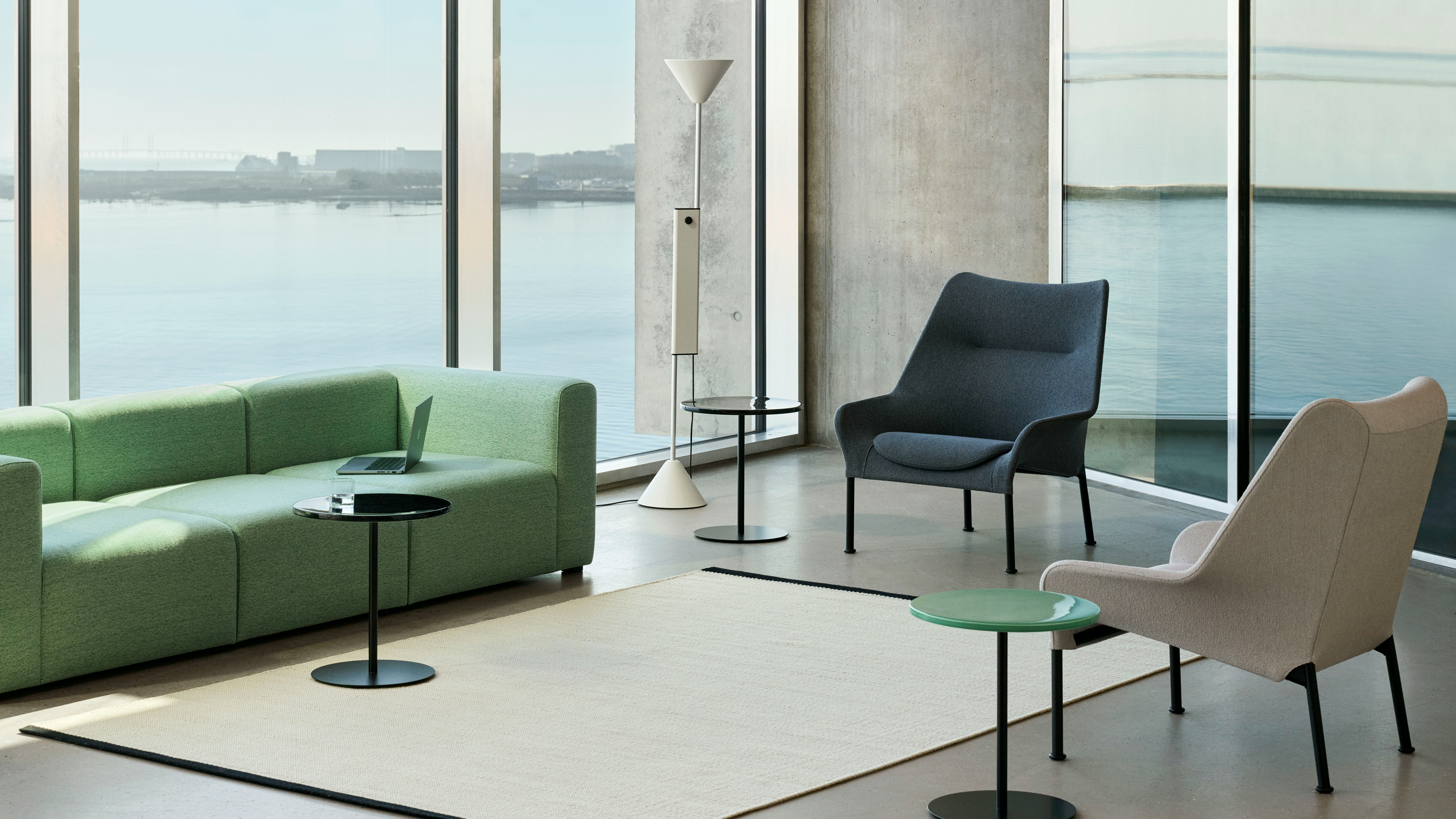 O2 Lounge Chairs in cream, gray, and black staged in an open lounge with Pyro Side tables and a Mags Sofa.