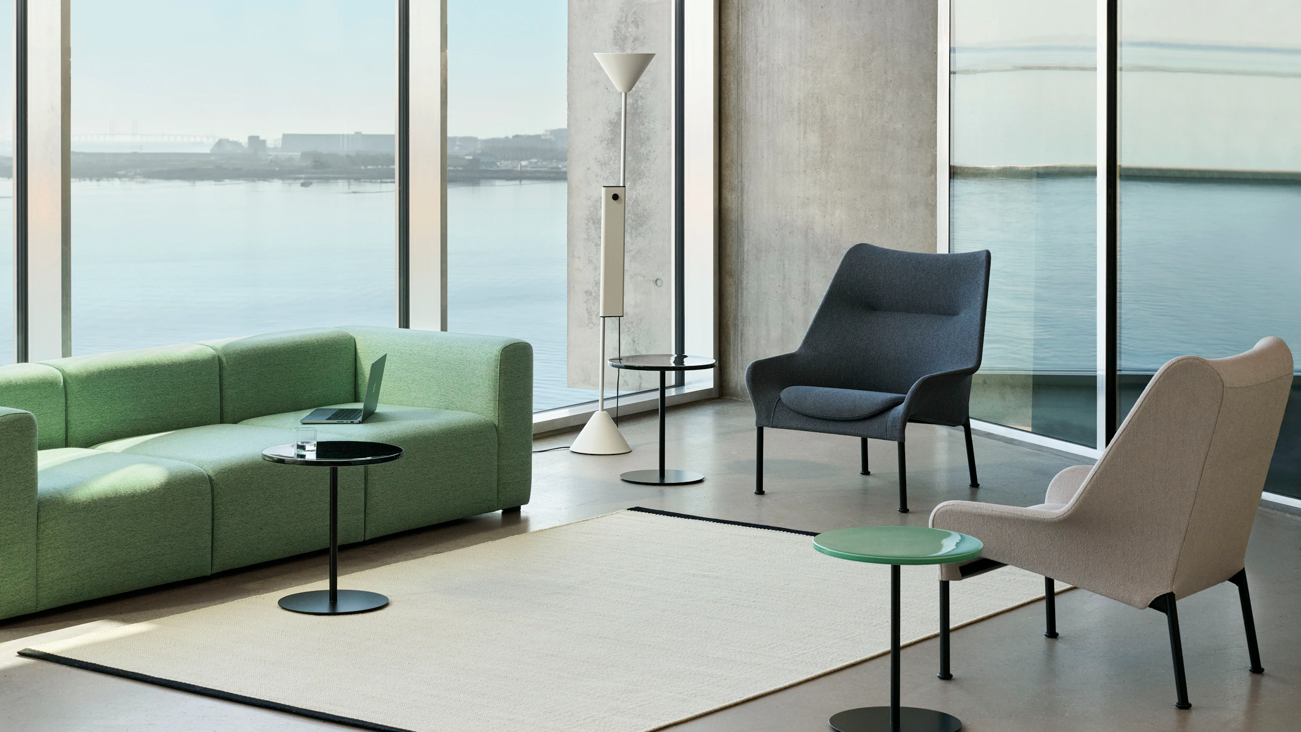 O2 Lounge Chairs in cream, gray, and black staged in an open lounge with Pyro Side tables and a Mags Sofa.