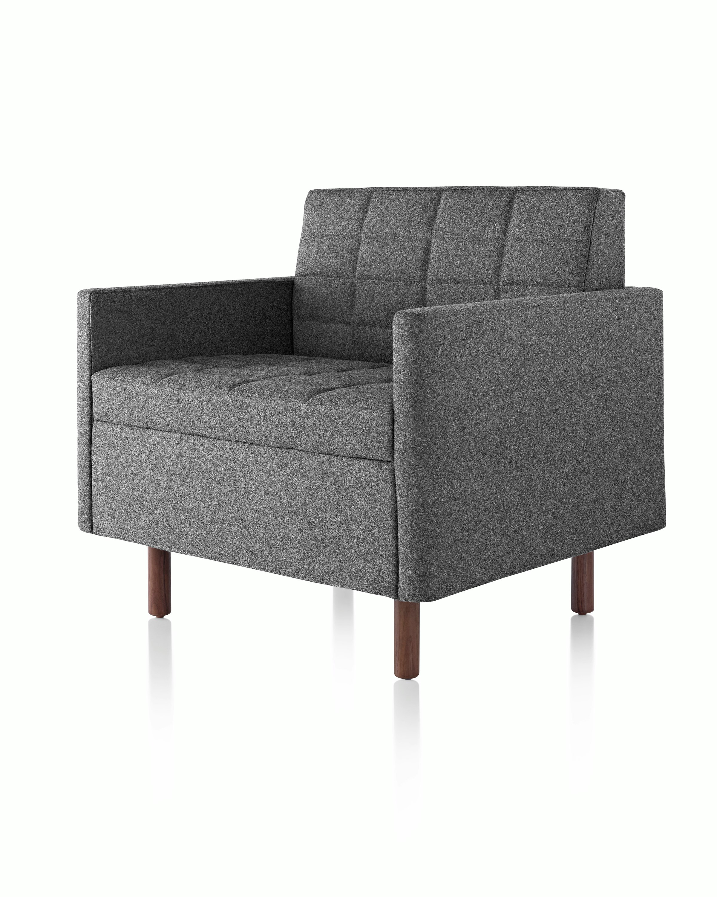 Angled view of a quilted Tuxedo Classic club chair upholstered in dark gray fabric.