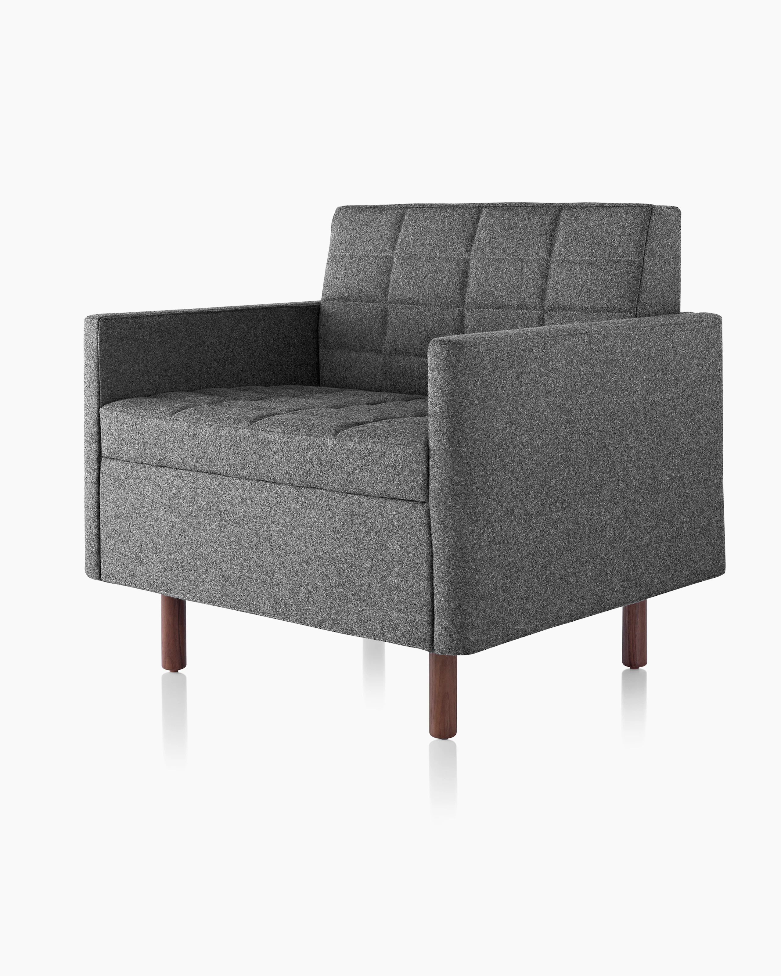 Angled view of a quilted Tuxedo Classic club chair upholstered in dark gray fabric.