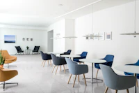 An informal meeting space featuring round Saiba occasional tables with Saiba Side Chairs upholstered in various shades of blue.