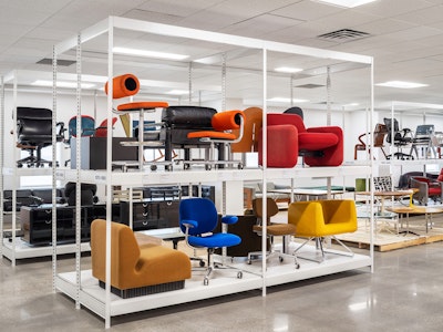 A variety of colorful seating from the MillerKnoll collective of brands on display on white racks at the MillerKnoll Archives