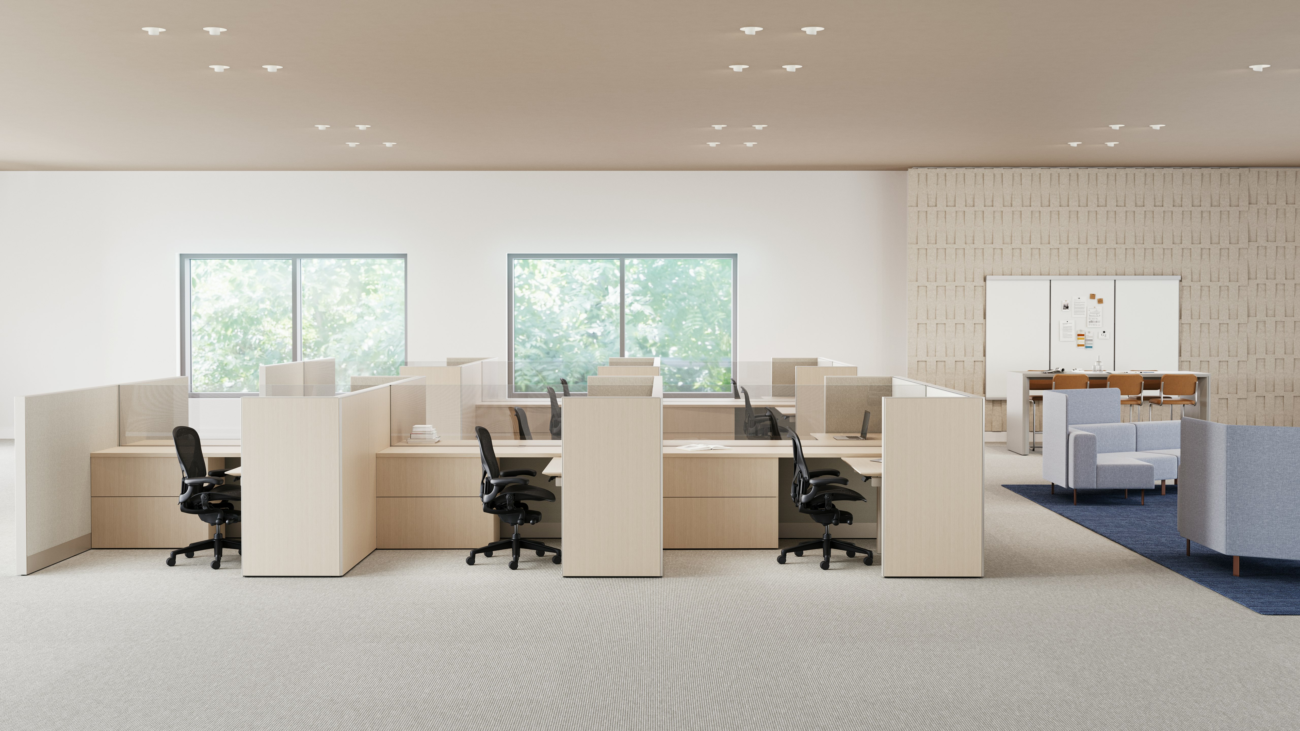 An open office is shown with workstations in light finishes and casual meeting spaces with lounge seating and collaborative spaces.
