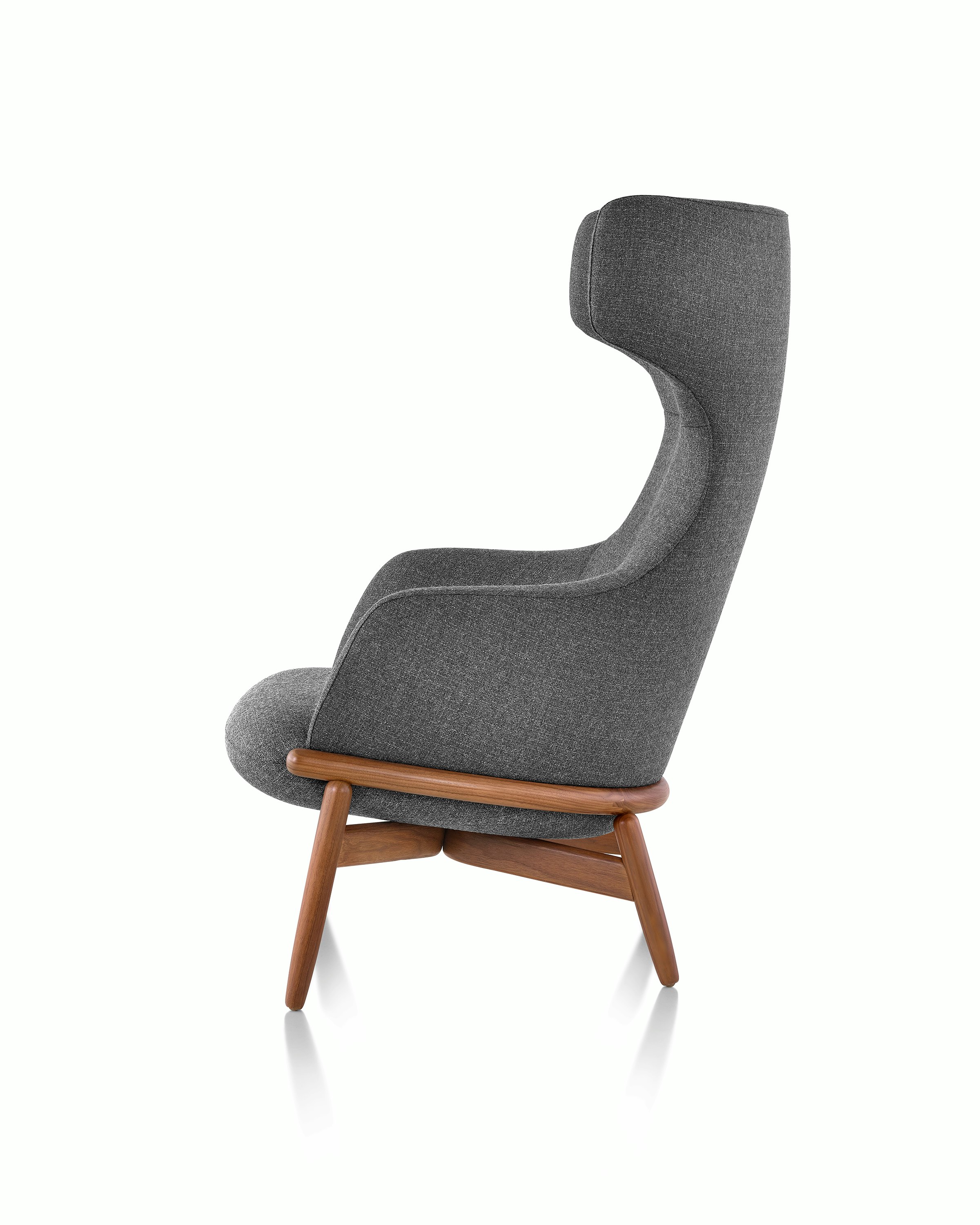 A wing-back Reframe Lounge Chair in Milaner Charcoal, viewed from the side.